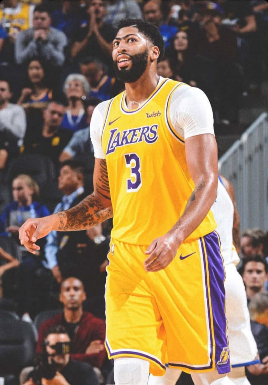 Anthony Davis 桌布 壁紙 — 一名身穿黃色湖人隊球衣、背號3的籃球運動員在比賽中專注地站立，背景是人群。