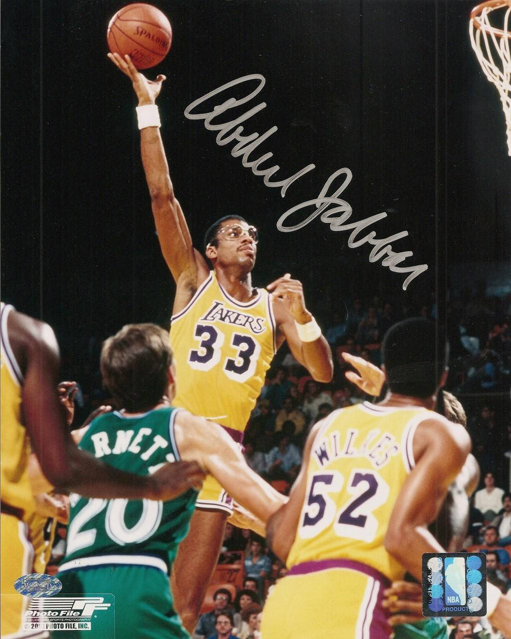 Kareem 桌布 壁紙 — 一名身穿黃色湖人隊球衣的籃球運動員在擁擠的場館中跳起投籃越過防守球員。
