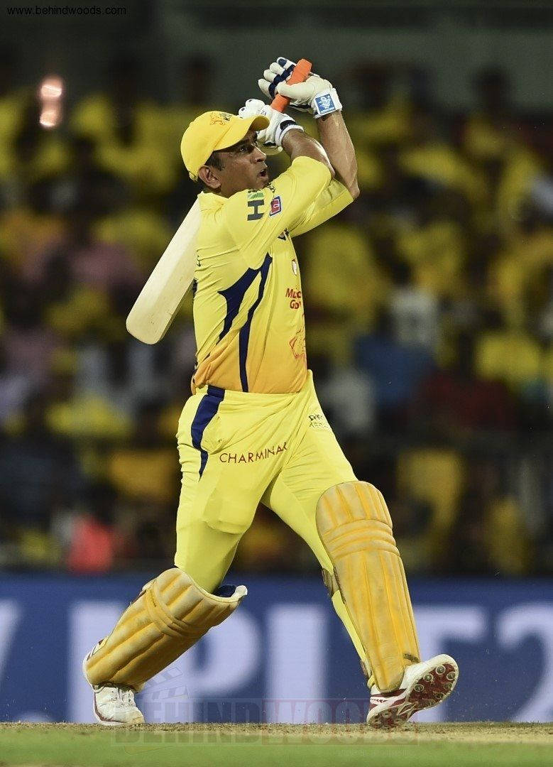 MS Dhoni 桌布 壁紙 — 一名身穿黃色球衣的板球擊球手在夜間比賽中，在球場燈光下強力揮棒。