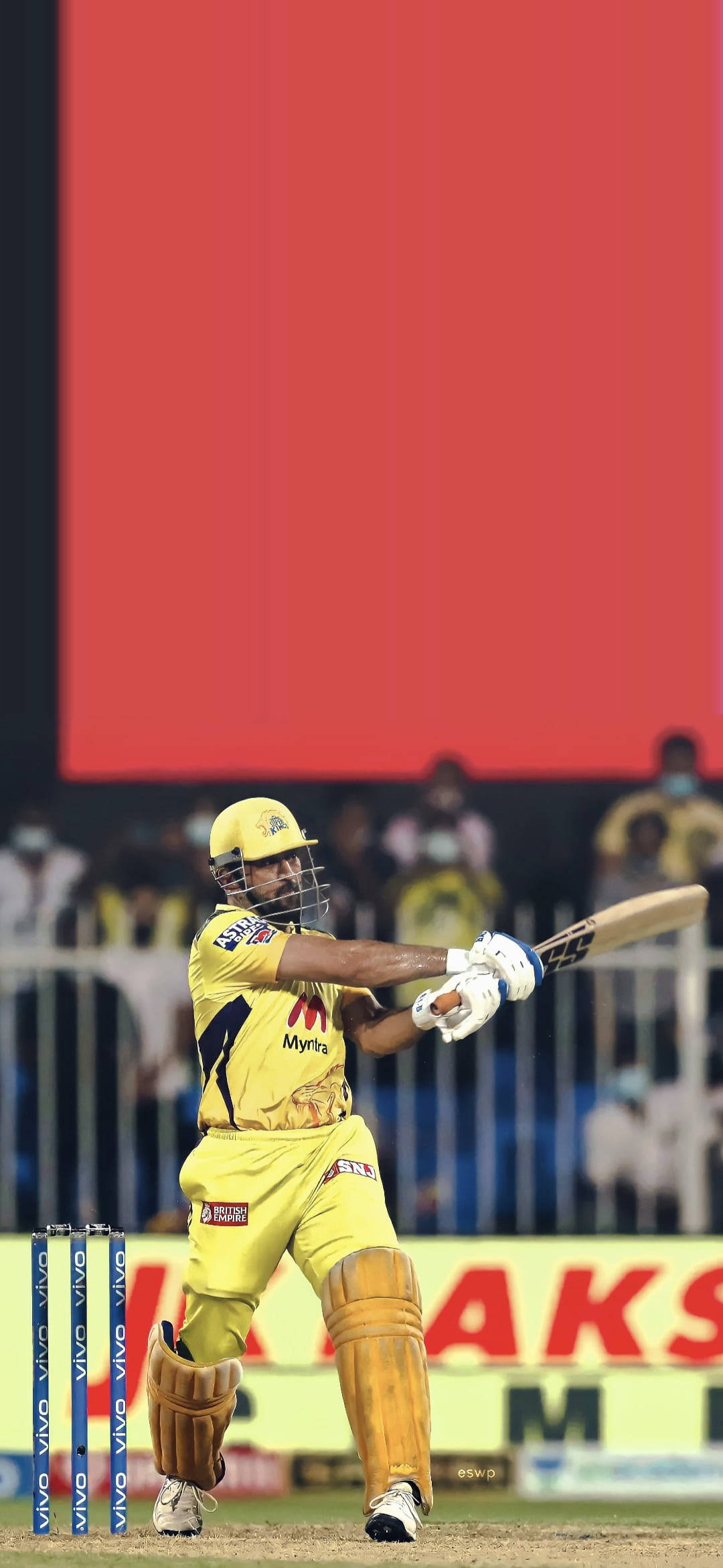 csk 2021 桌布 壁紙 — 一名身穿黃色球衣的板球擊球手在明亮的體育場燈光下，於夜間比賽中強力揮動球棒。
