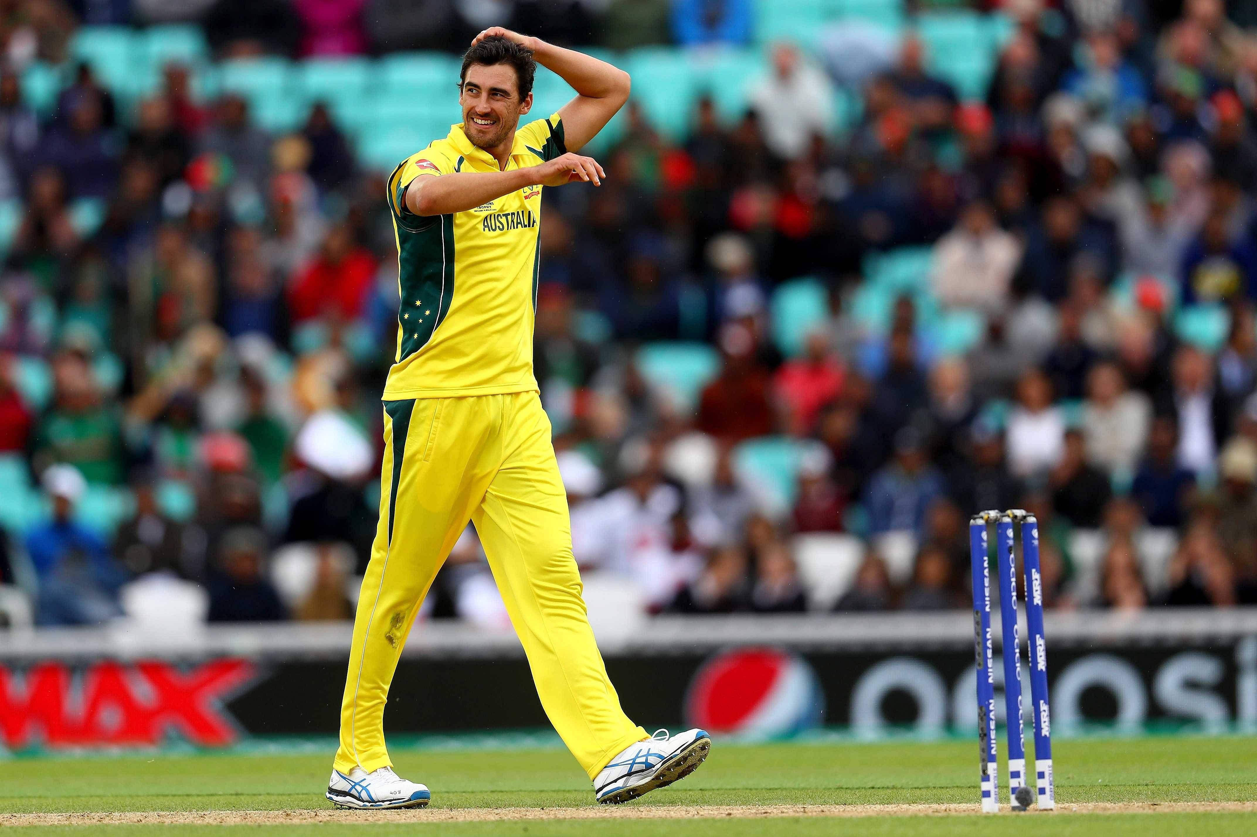 australia cricket 桌布 壁紙 — 一名身穿黃色球衣的澳洲板球運動員在綠色球場上高舉雙臂慶祝一個三柱門。