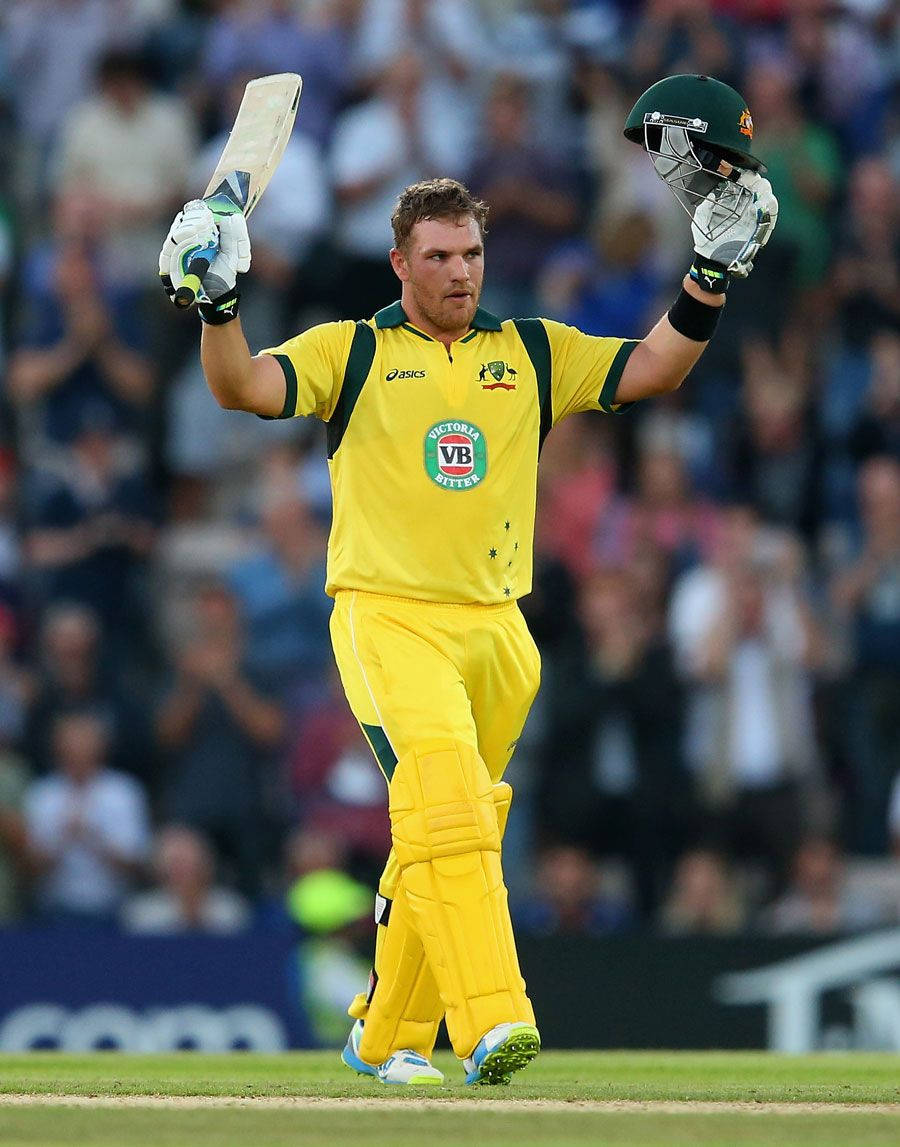 Aaron Finch 桌布 壁紙 — 一名身穿黃色球衣的澳洲板球選手在歡呼的人群中高舉球棒和頭盔慶祝。