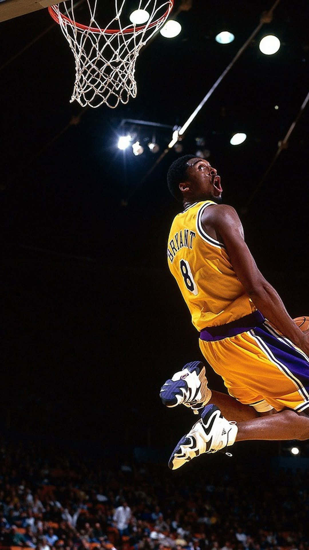 Aesthetic NBA 桌布 壁紙 — 一名身穿黃色球衣的籃球運動員在場館燈光下專注地灌籃。