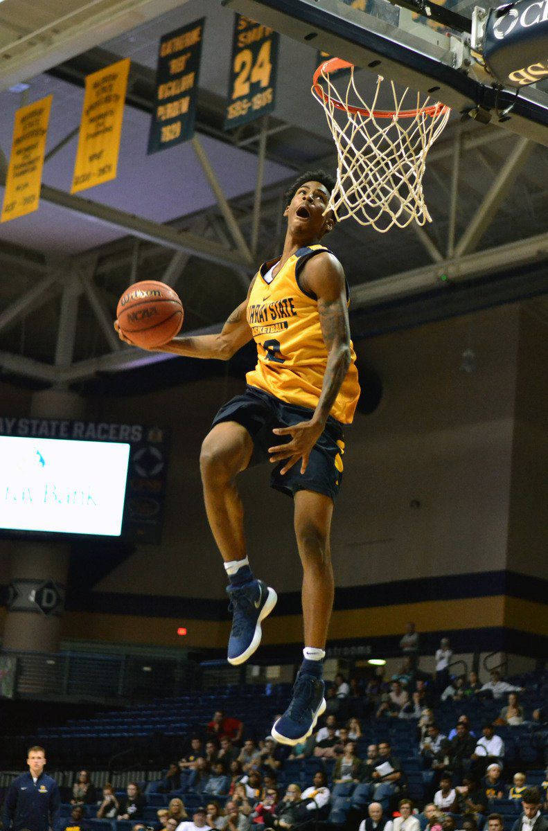 Ja Morant 灌籃 桌布 壁紙 — 一名身穿黃色球衣的籃球運動員在明亮的場館燈光下，專注地灌籃。