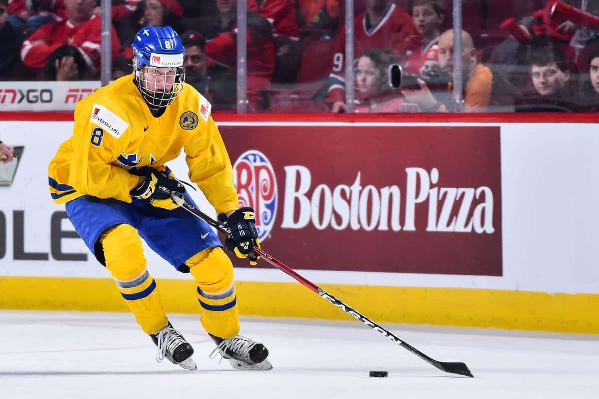 hockey 桌布 壁紙 — 一名身穿黃藍色球衣的瑞典冰球運動員在比賽期間於冰場上激烈地滑行並持桿。