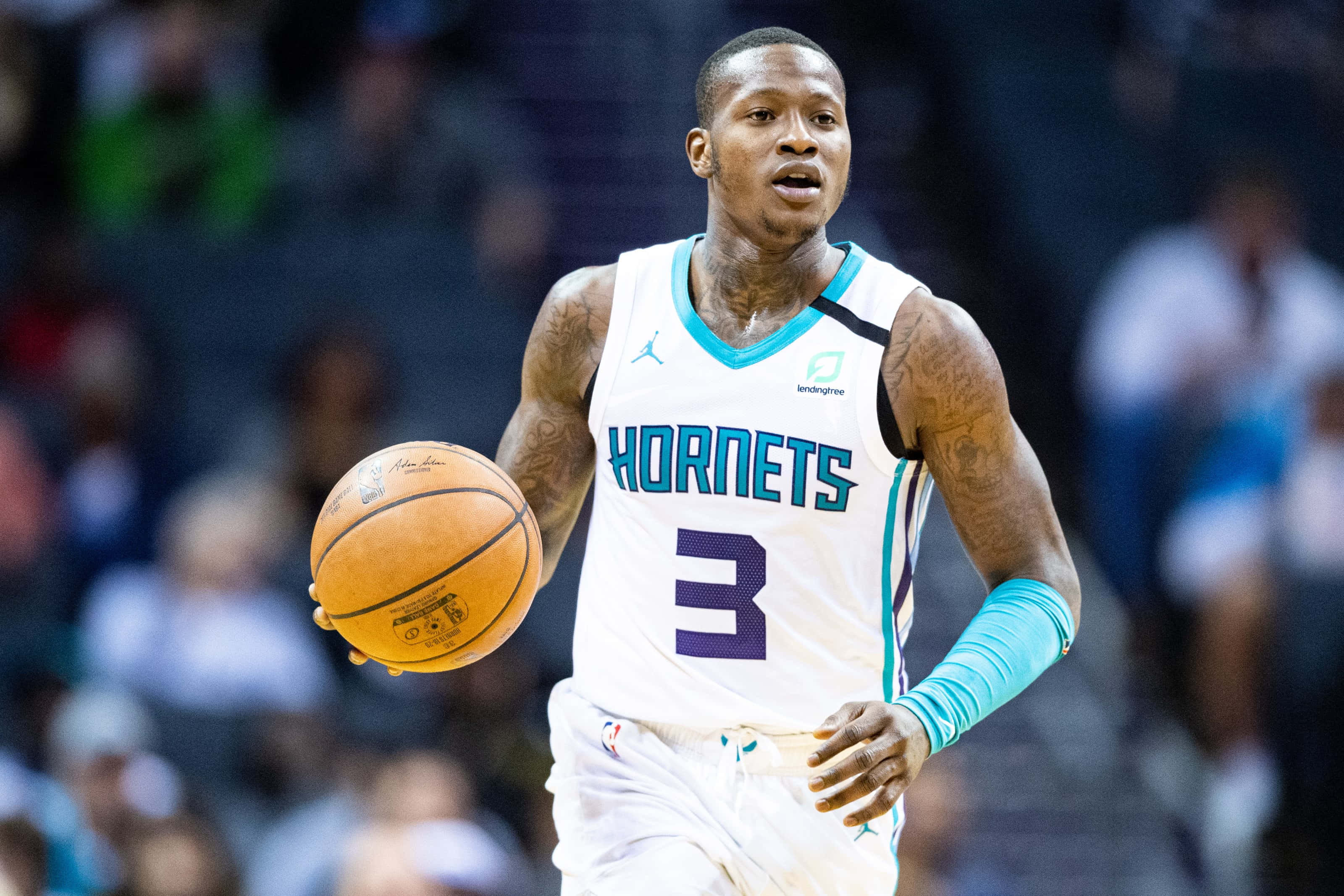 NBA 桌布 壁紙 — 一名身穿黃蜂隊球衣的籃球運動員在明亮的場館燈光下，於激烈的比賽中運球。