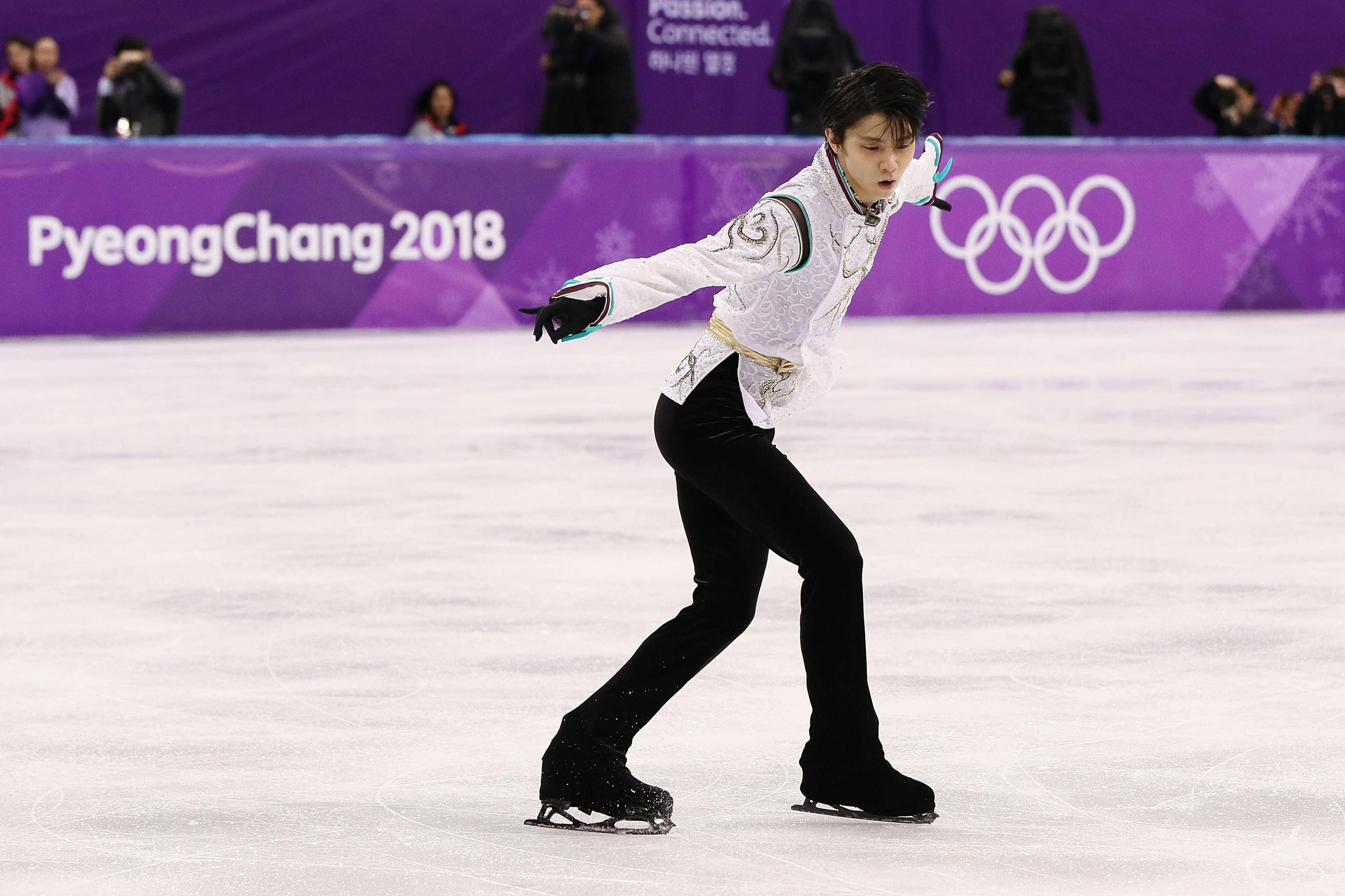 Winter Olympics 桌布 壁紙 — 一名身穿黑白服裝的男性花式滑冰選手在平昌2018冬季奧運會的冰面上表演優雅的旋轉。