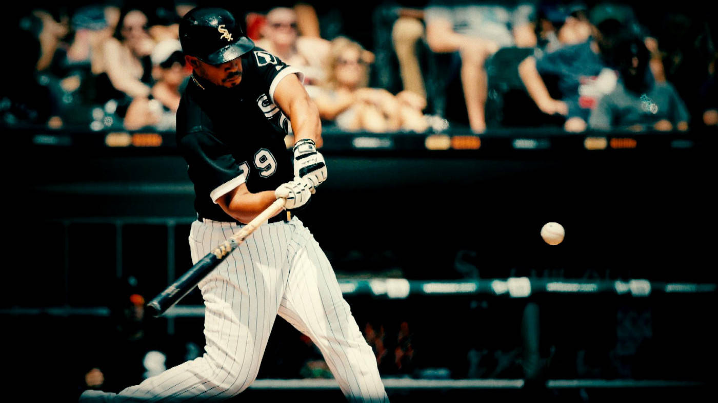jose abreu 桌布 壁紙 — 一名身穿黑白條紋球衣的棒球選手在夜間比賽中揮棒擊球，背景是模糊的觀眾。