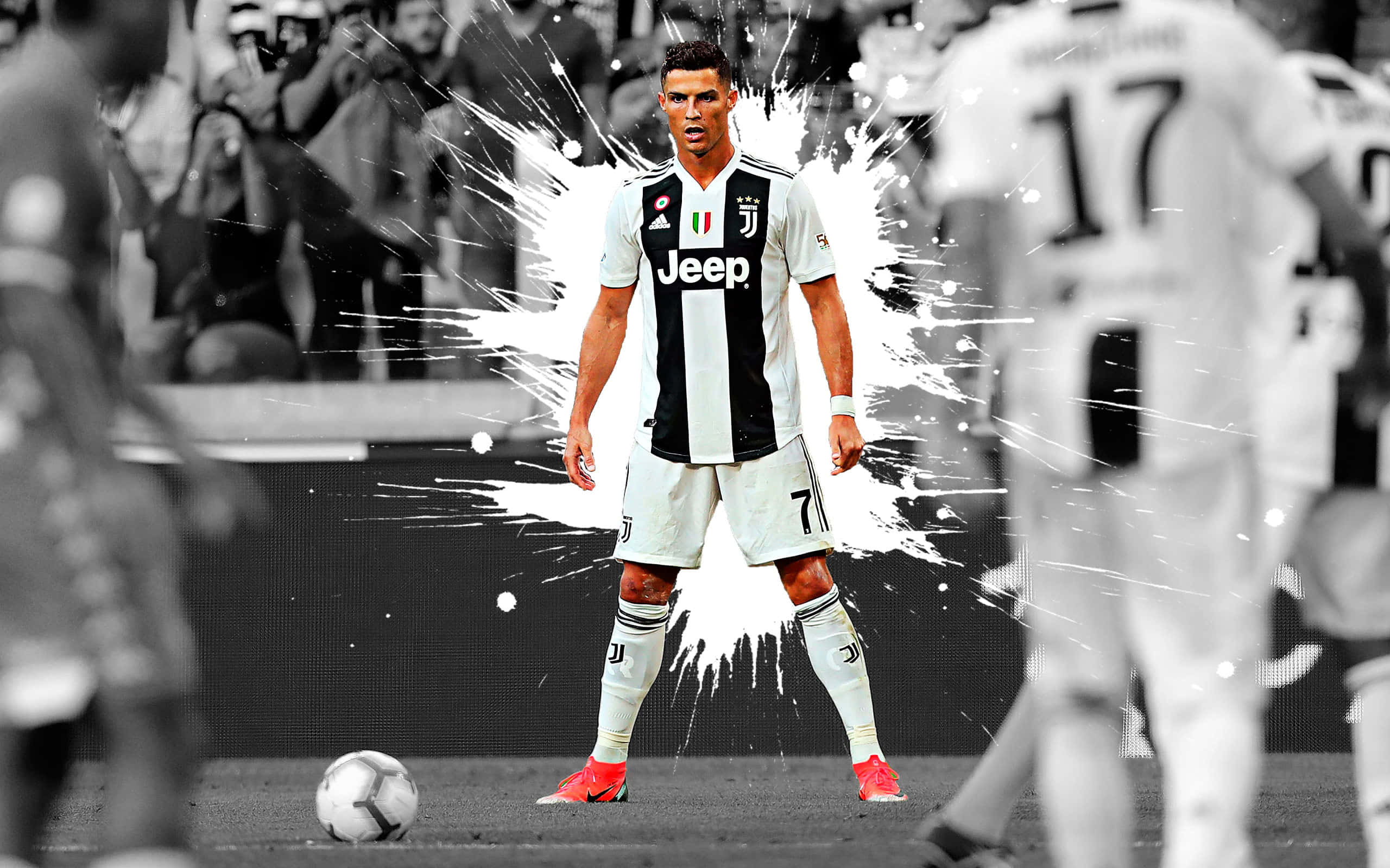 Juventus 桌布 壁紙 — 一名身穿黑白條紋球衣的足球員自信地站在球場上，背後有戲劇性的白色油漆噴濺效果。