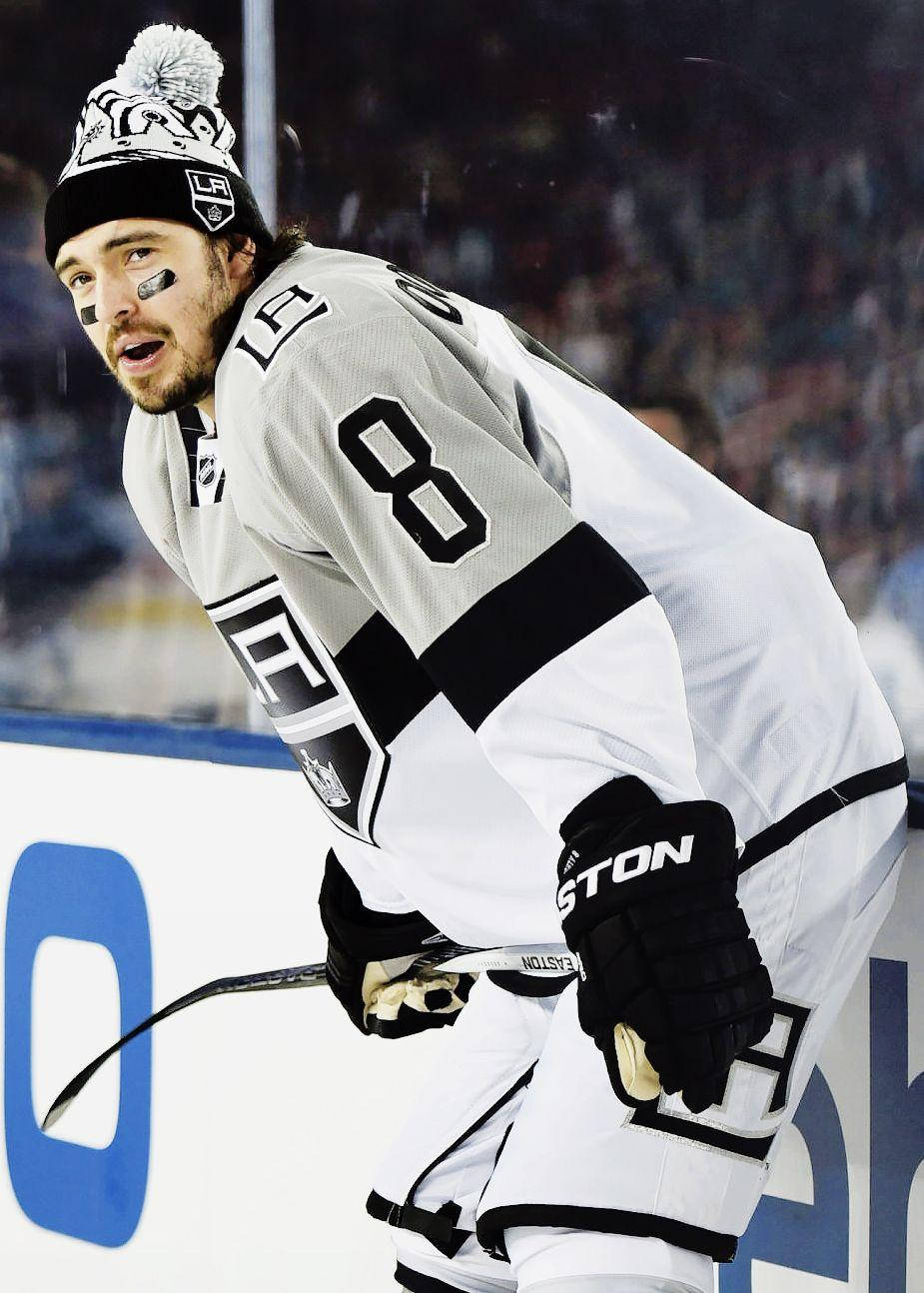 hockey 桌布 壁紙 — 一名身穿黑白球衣的冰球運動員在比賽中專注地俯身在冰面上。