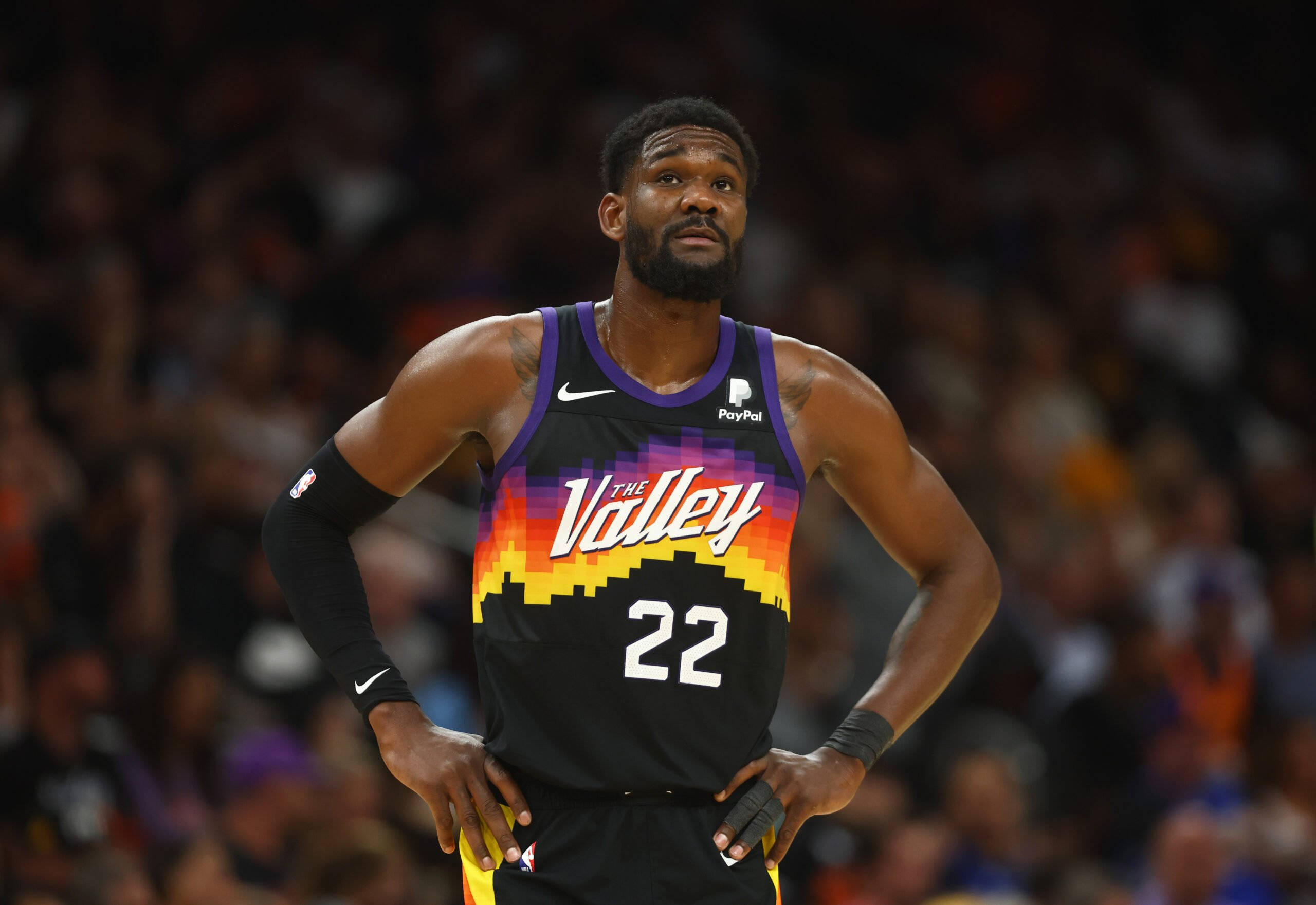 NBA 桌布 壁紙 — 一名身穿黑紫色Suns球衣、印有「The Valley」及22號的籃球運動員，在球場燈光下雙手叉腰站立比賽中。