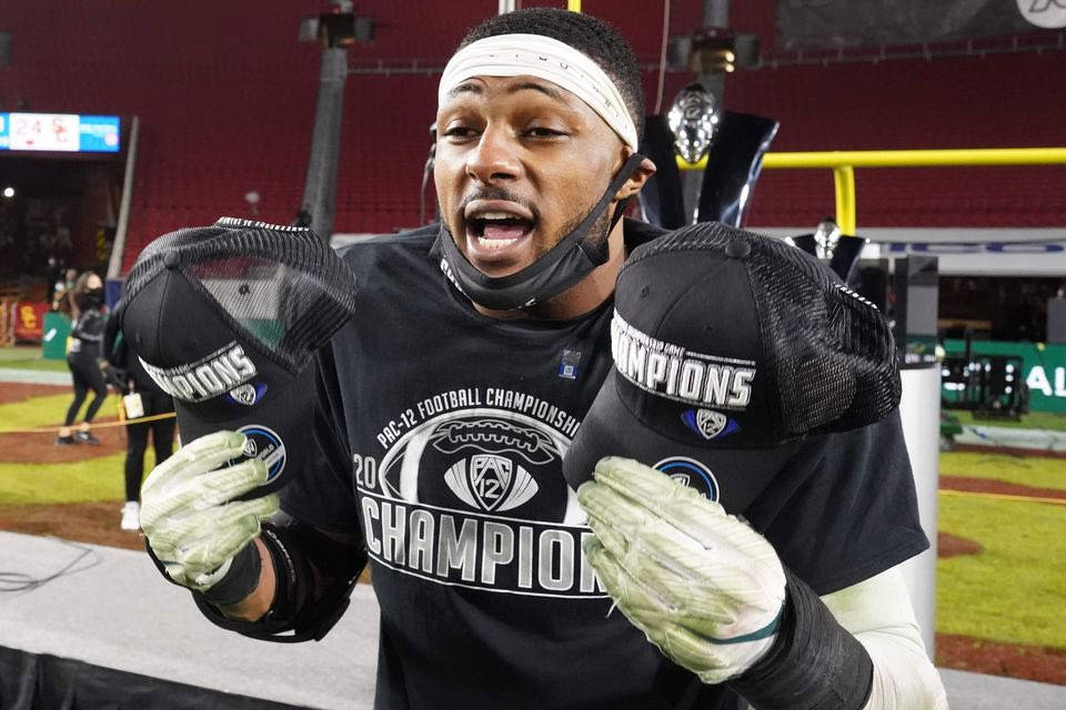 足球 桌布 壁紙 — 一名身穿黑色「Champions」球衣和手套的足球運動員在夜間的球場上勝利慶祝。