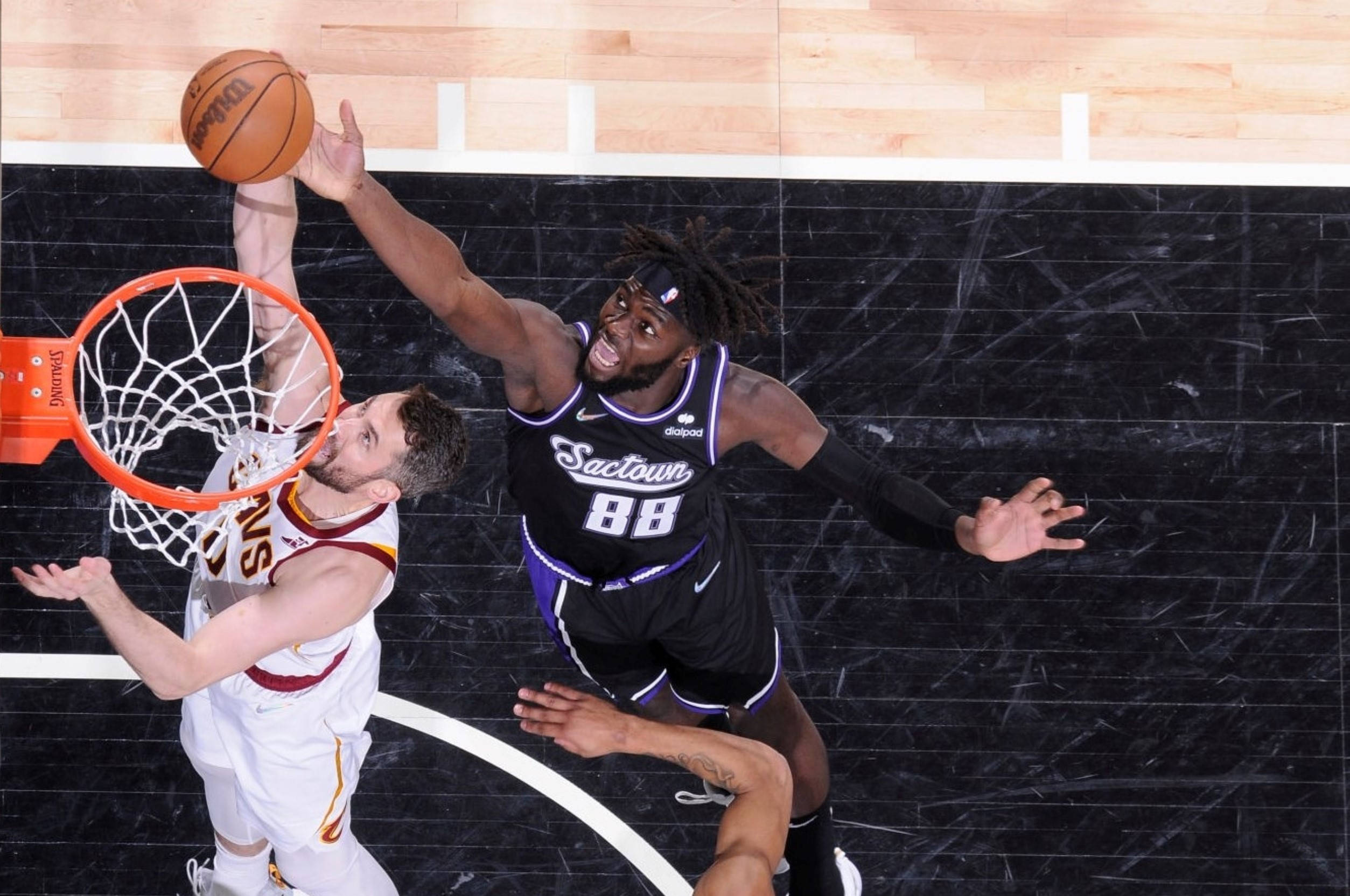 Kevin Love 桌布 壁紙 — 一名身穿黑色 'Sactown 88' 球衣的籃球運動員跳起封阻投籃，而一名身穿白色球衣的對手則嘗試在籃框附近得分。