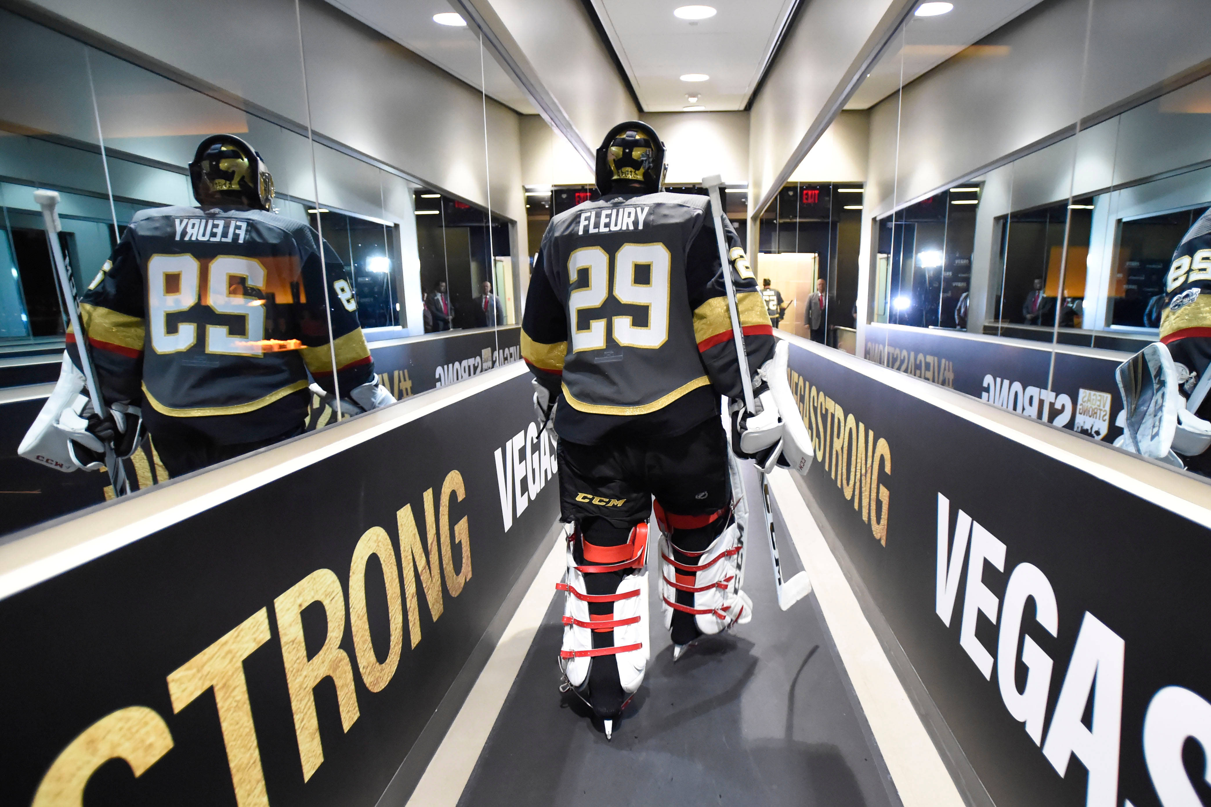 hockey 桌布 壁紙 — 一名身穿黑色、金色和紅色裝備的冰球守門員，走過一條掛有「STRONG VEGAS」橫幅的鏡面隧道。