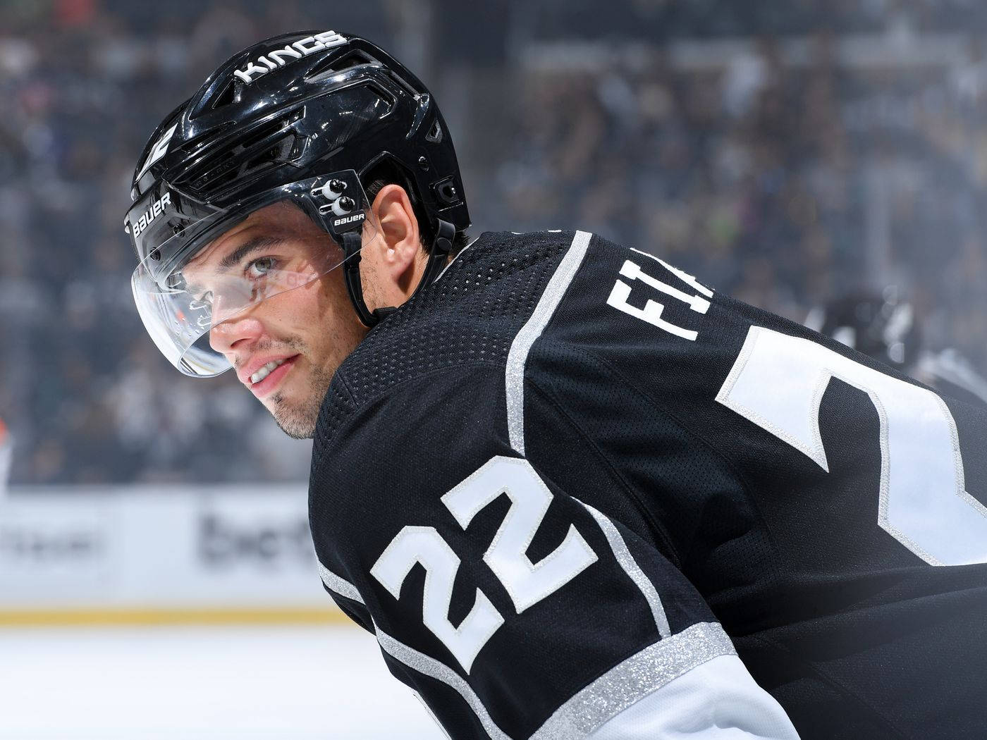 hockey 桌布 壁紙 — 一名身穿黑色Kings球衣22號的冰上曲棍球運動員在冰場上向前傾身比賽。