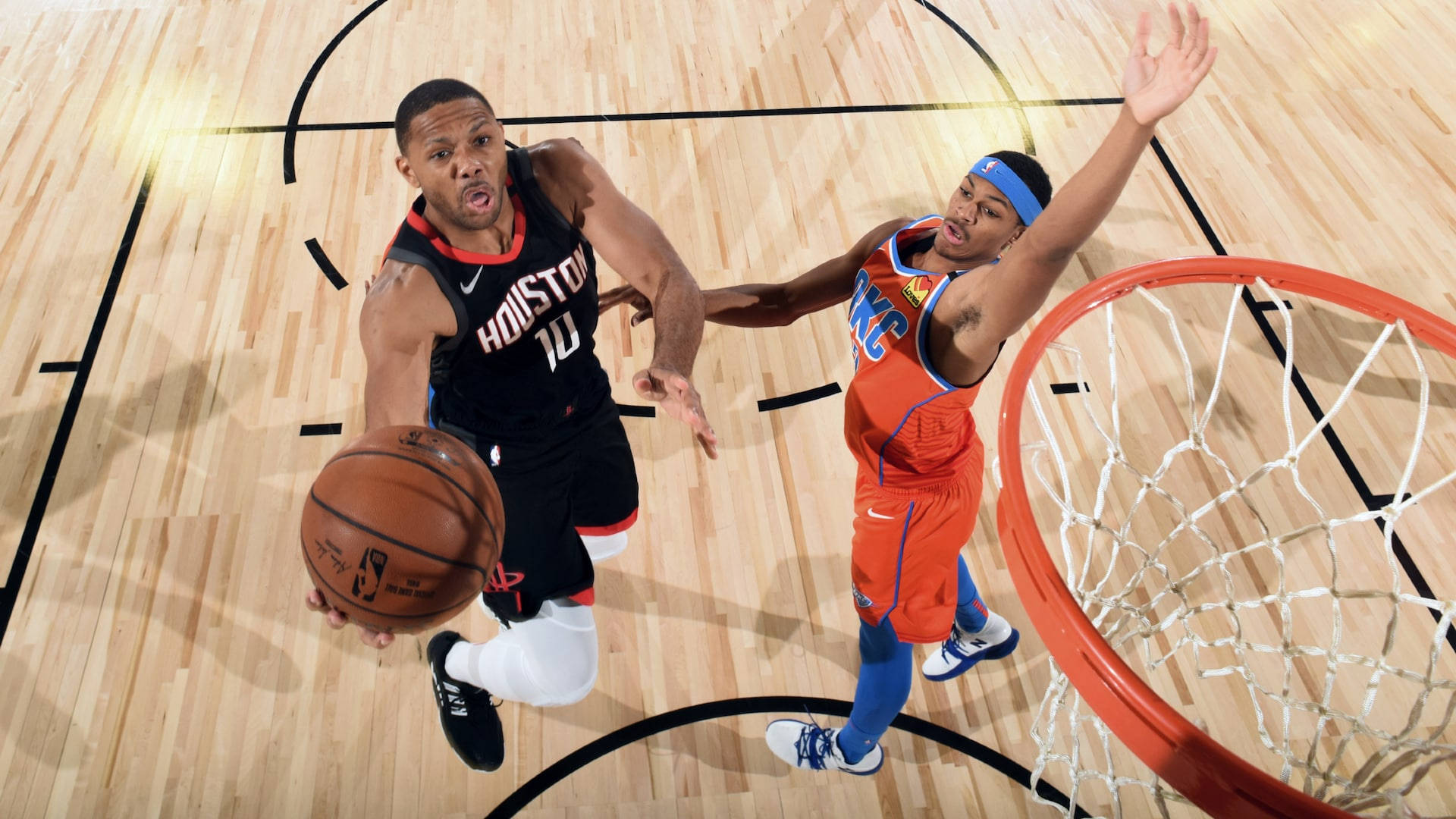 eric gordon 桌布 壁紙 — 一名身穿黑色休士頓球衣的籃球運動員在橙色對手的防守下向籃框切入。