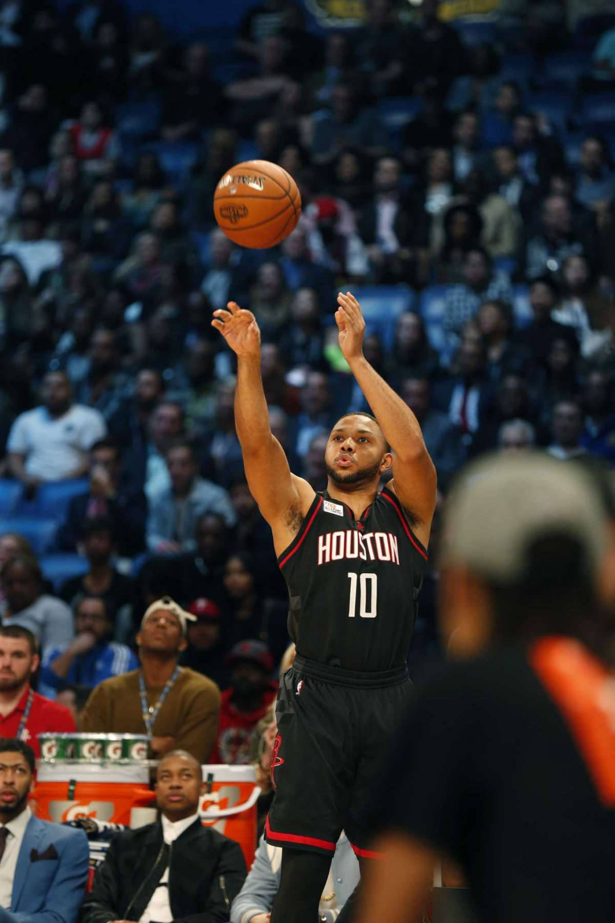 eric gordon 桌布 壁紙 — 一名身穿黑色休士頓球衣的籃球運動員在比賽中於半空中投籃，背景是模糊的人群。