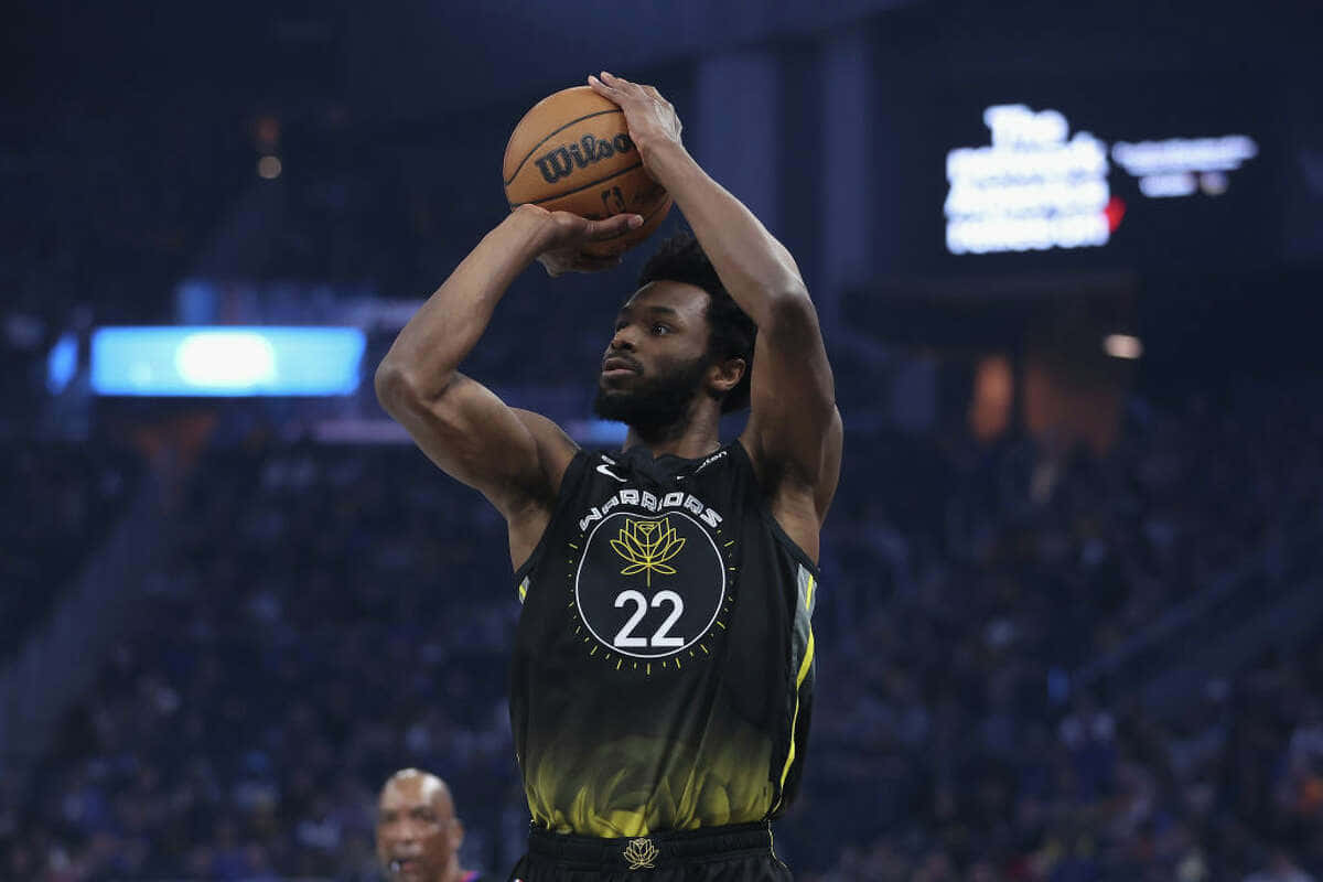 Andrew Wiggins 桌布 壁紙 — 一名身穿黑色勇士隊球衣、背號22的籃球運動員在場館燈光下準備投籃。