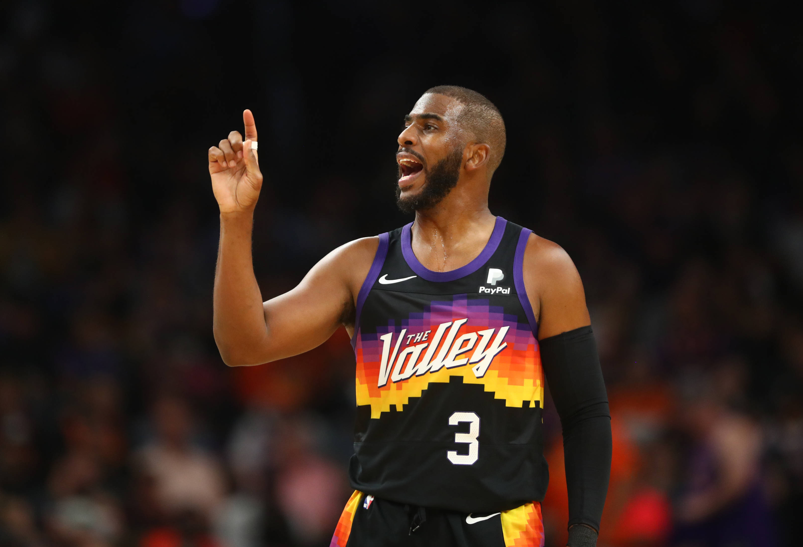 Suns 桌布 壁紙 — 一名身穿黑色和橙色太陽隊球衣、背號3號的籃球運動員在比賽中激烈地向上指。