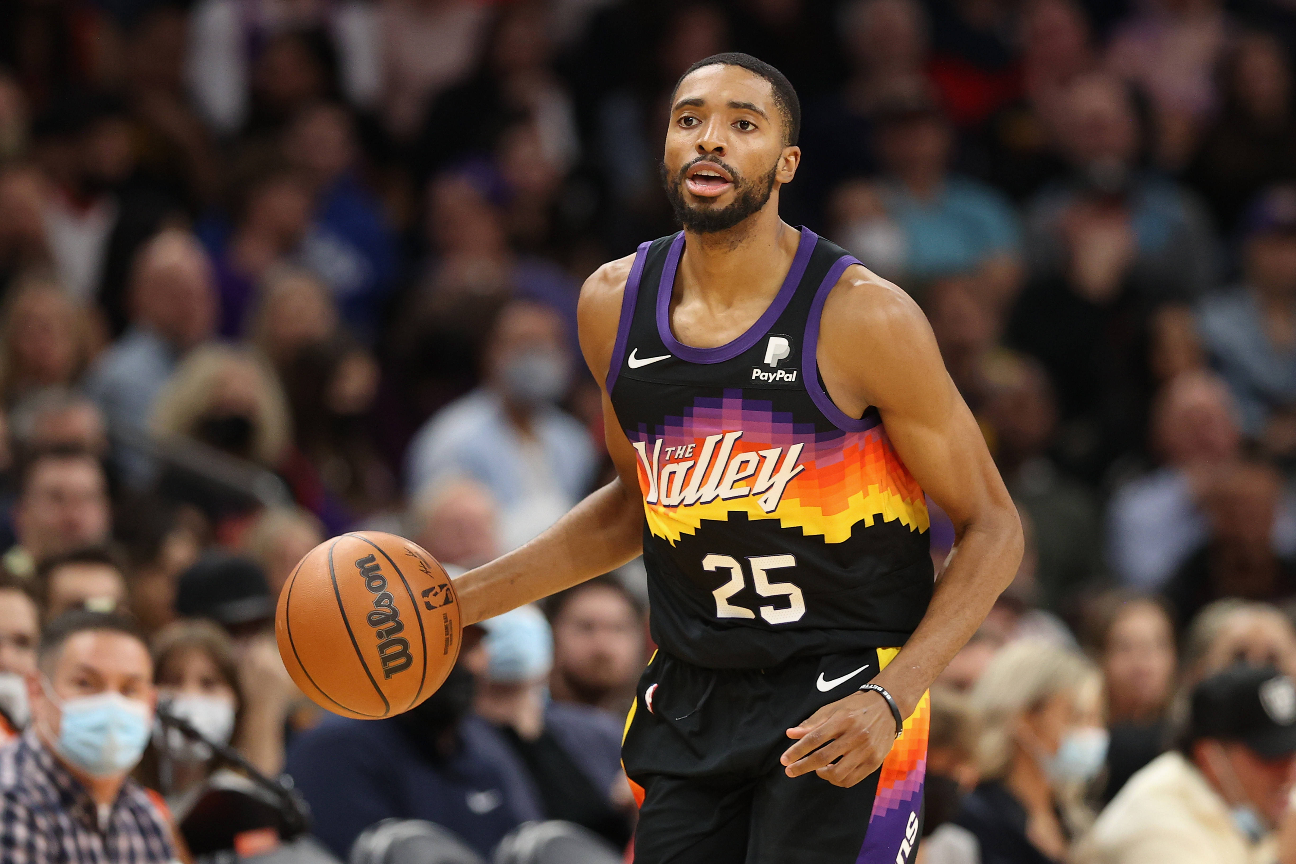 NBA 桌布 壁紙 — 一名身穿黑色和紫色Suns球衣的籃球運動員在比賽中運球，背景是模糊的人群。