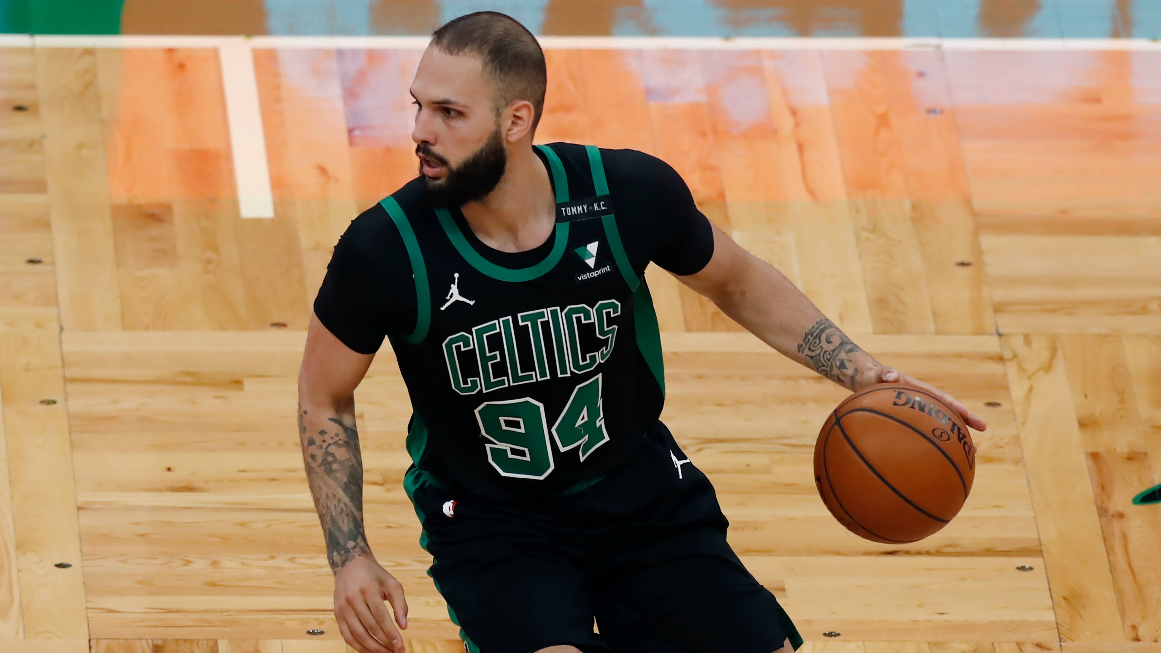 NBA 桌布 壁紙 — 一名身穿黑色和綠色塞爾提克球衣的籃球運動員在木地板上運球比賽。