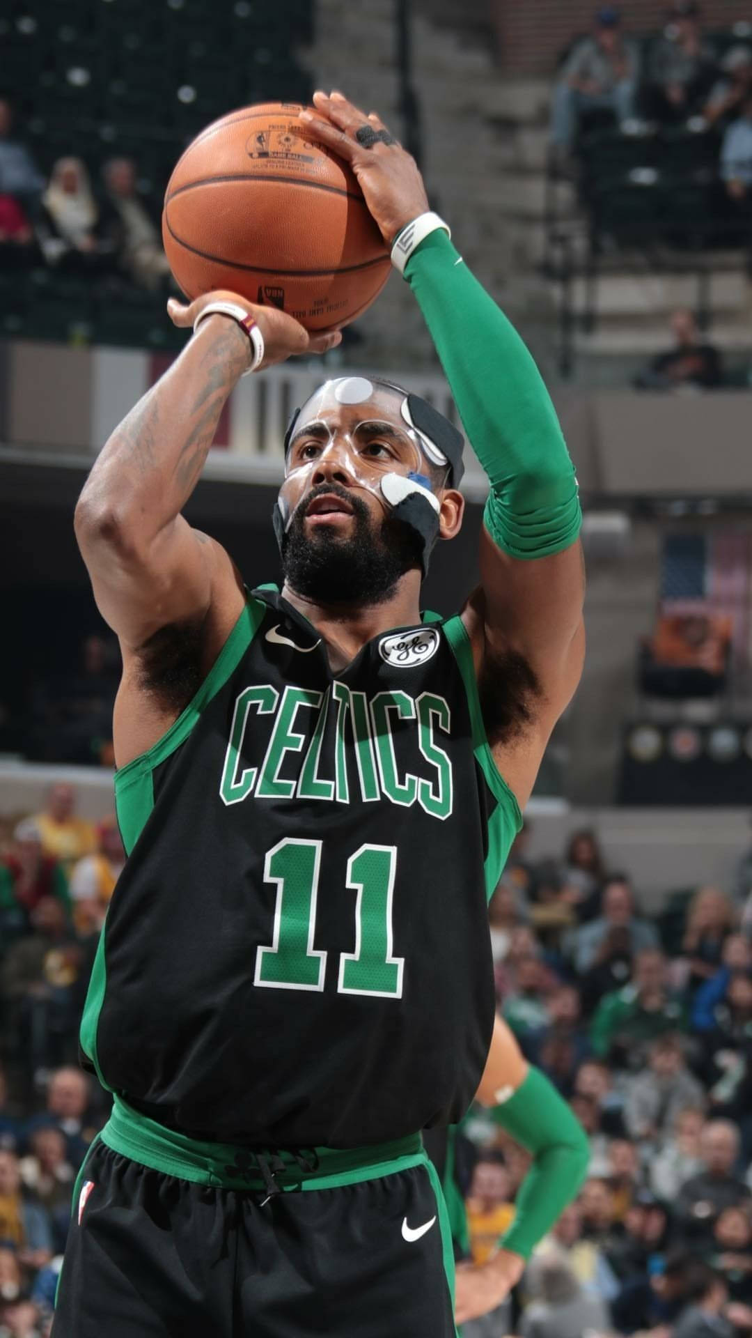 Kyrie 桌布 壁紙 — 一名身穿黑色和綠色球衣的波士頓塞爾提克籃球運動員在比賽中準備投籃，背景有觀眾。