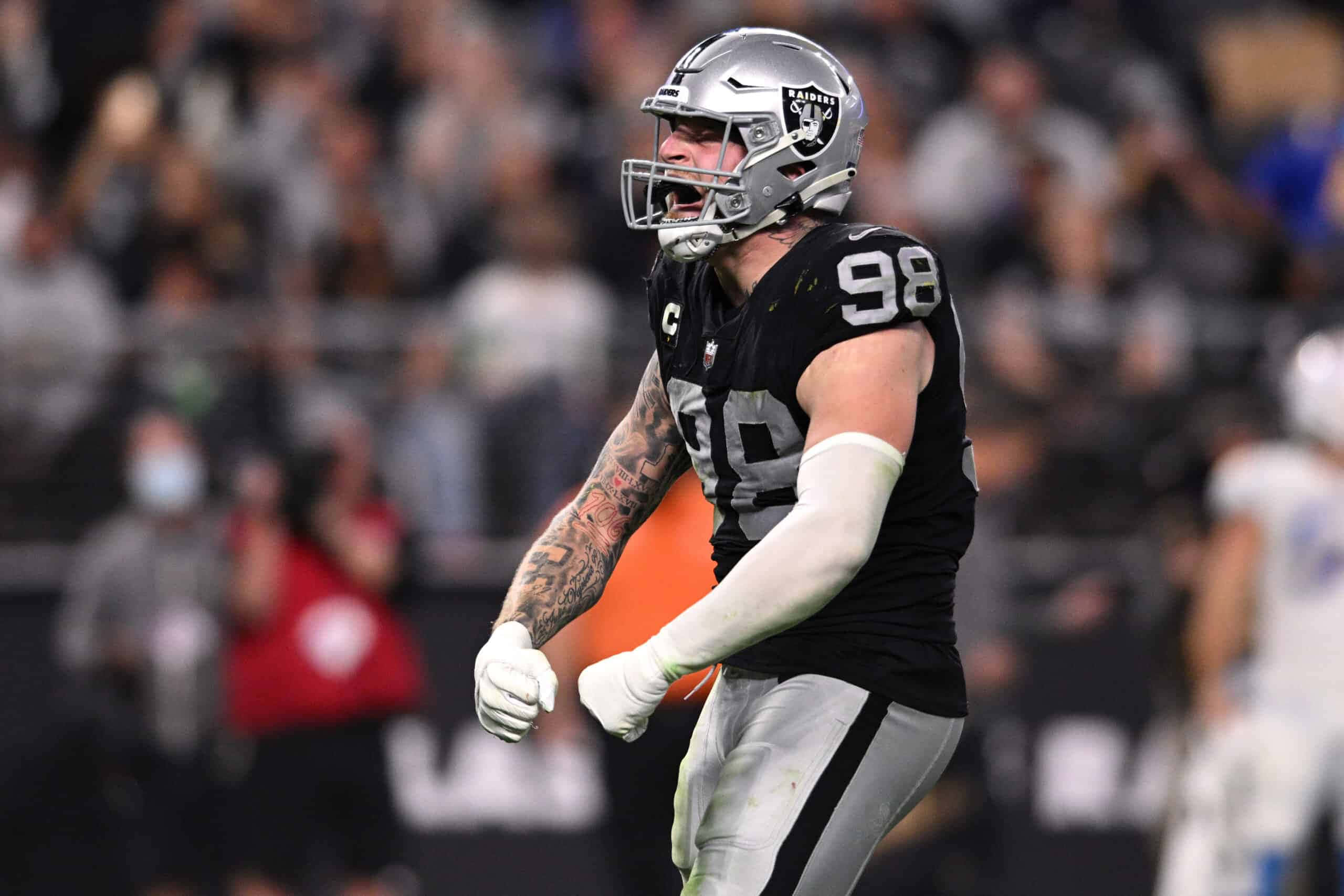Las Vegas Raiders 桌布 壁紙 — 一名身穿黑色和銀色球衣、號碼98的美式足球員在比賽期間於球場上激烈慶祝。
