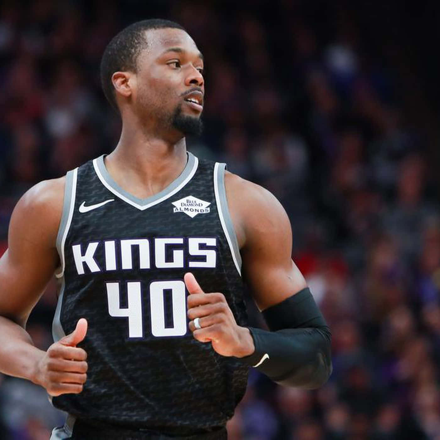NBA 桌布 壁紙 — 一名身穿黑色國王隊球衣、號碼40的籃球運動員在明亮的場館燈光下比賽時豎起兩個大拇指。