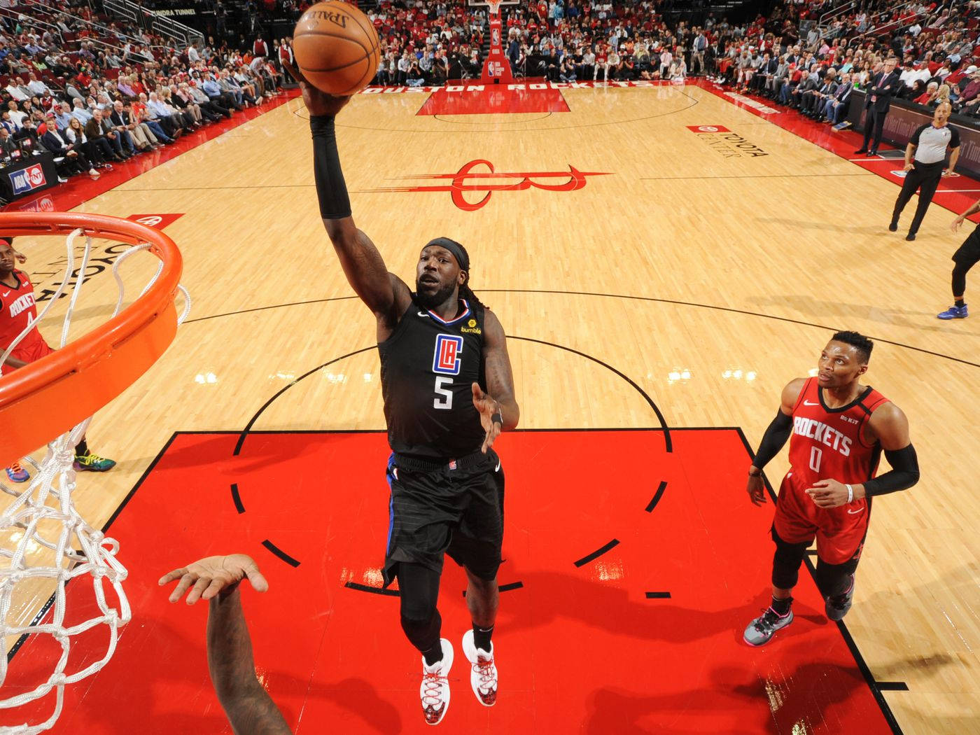 montrezl harrell 桌布 壁紙 — 一名身穿黑色快艇隊球衣的籃球運動員在比賽中跳向籃框，球高舉過頭。