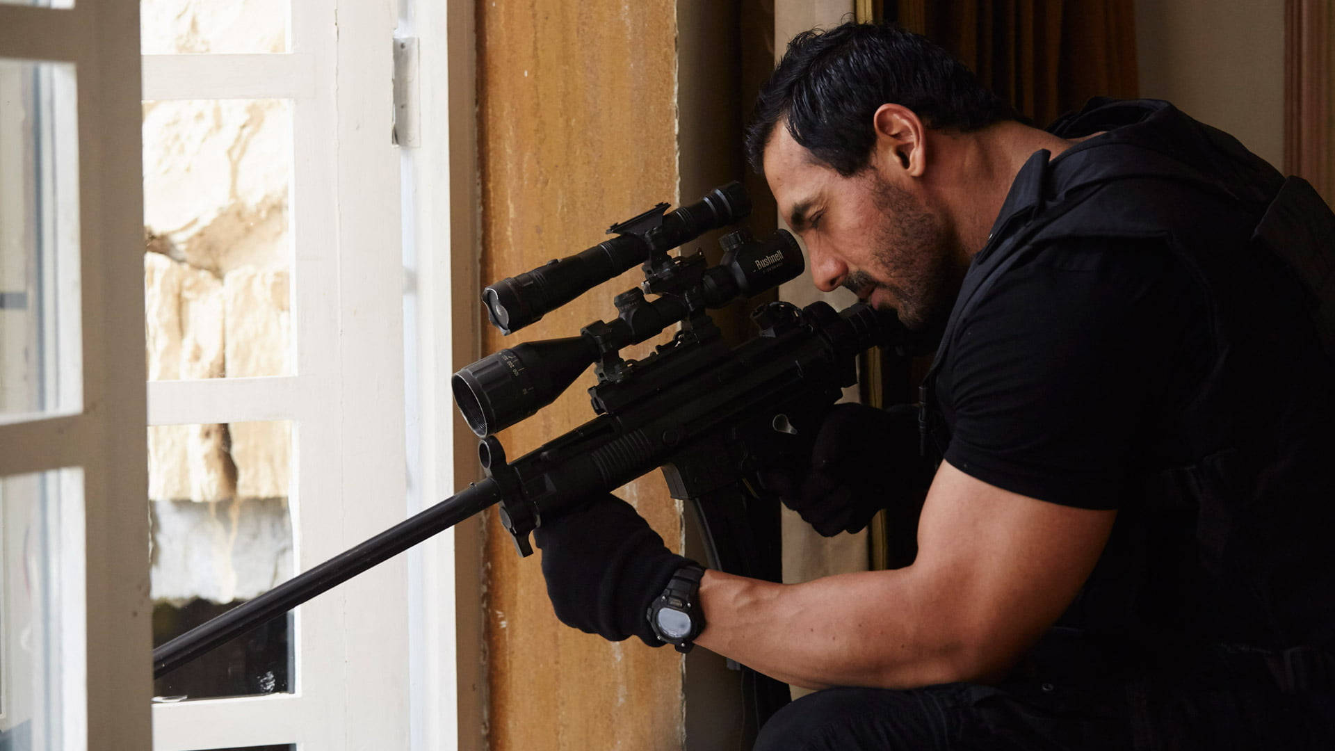 John Abraham 桌布 壁紙 — 一名身穿黑色戰術裝備的男子蹲在窗邊，全神貫注地瞄準狙擊步槍。