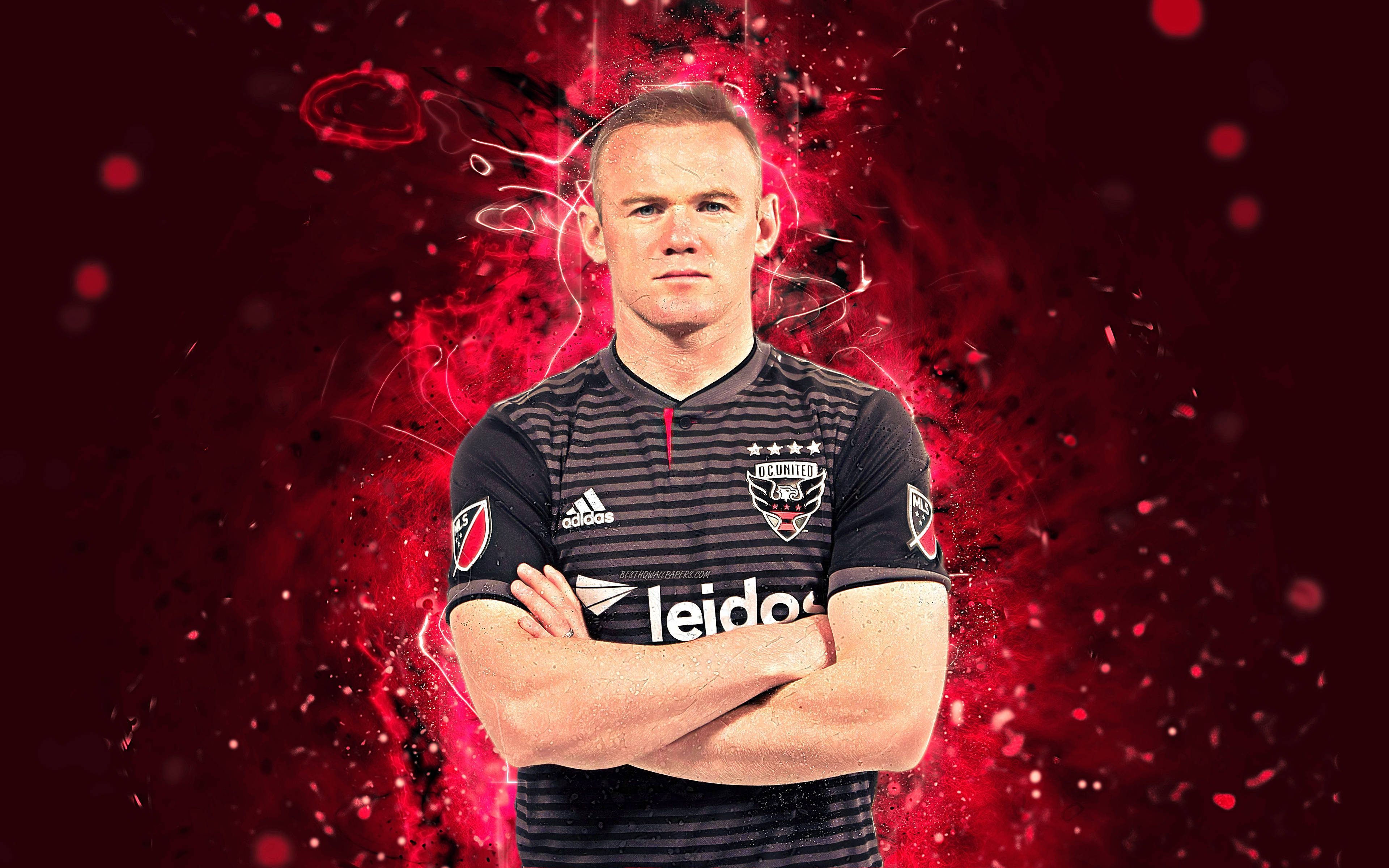 Rooney 桌布 壁紙 — 一名身穿黑色條紋球衣的足球運動員，在充滿活力的紅色爆炸背景前自信地交叉雙臂站立。