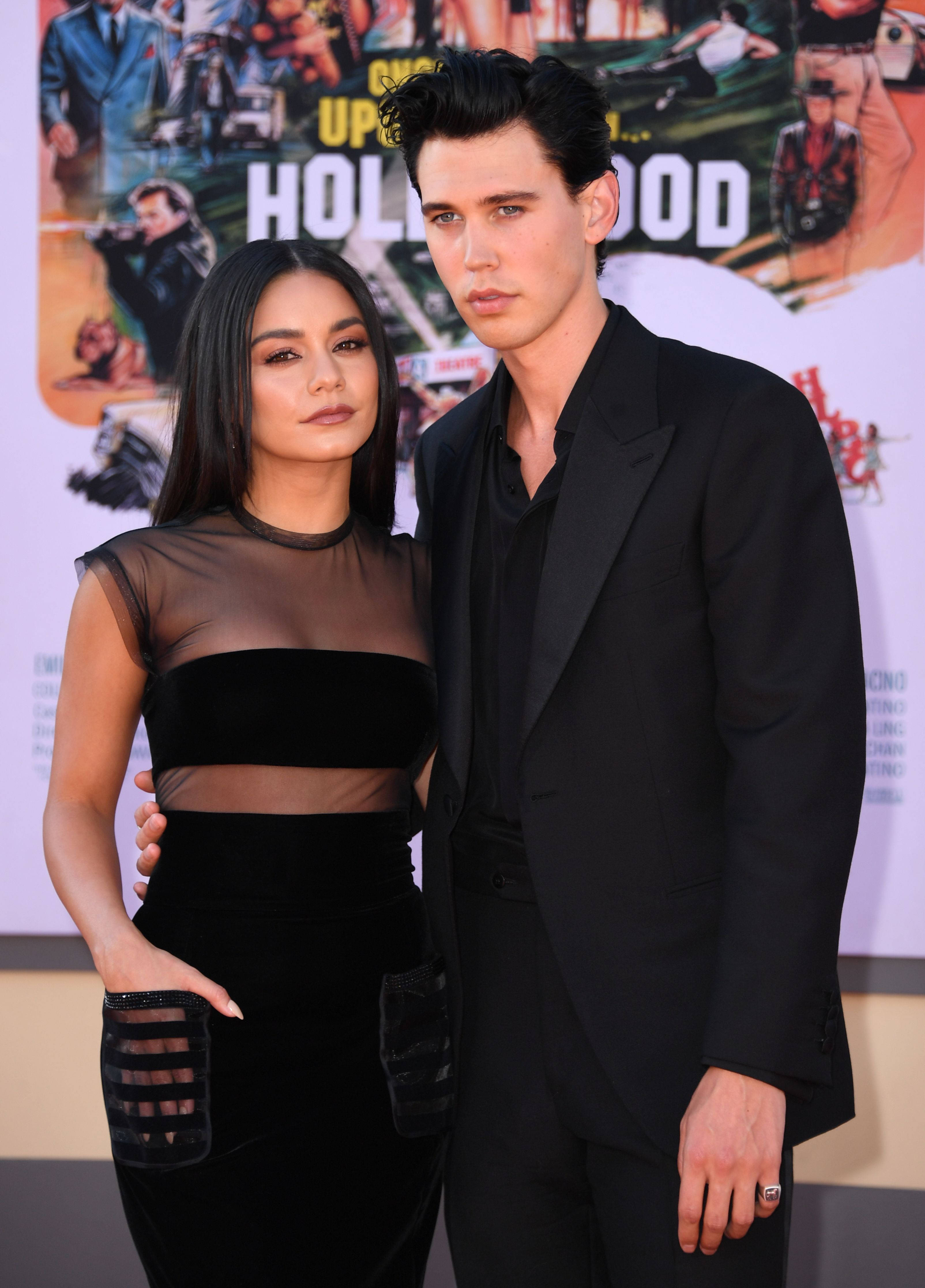 Celebrity 桌布 壁紙 — 一名身穿黑色正裝的男士和女士在好萊塢主題背景的電影首映禮上一起擺姿勢。