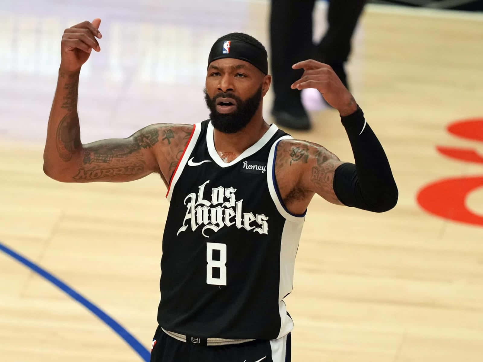 NBA 桌布 壁紙 — 一名身穿黑色洛杉磯球衣、背號8號的籃球運動員在木地板上激情地做手勢。