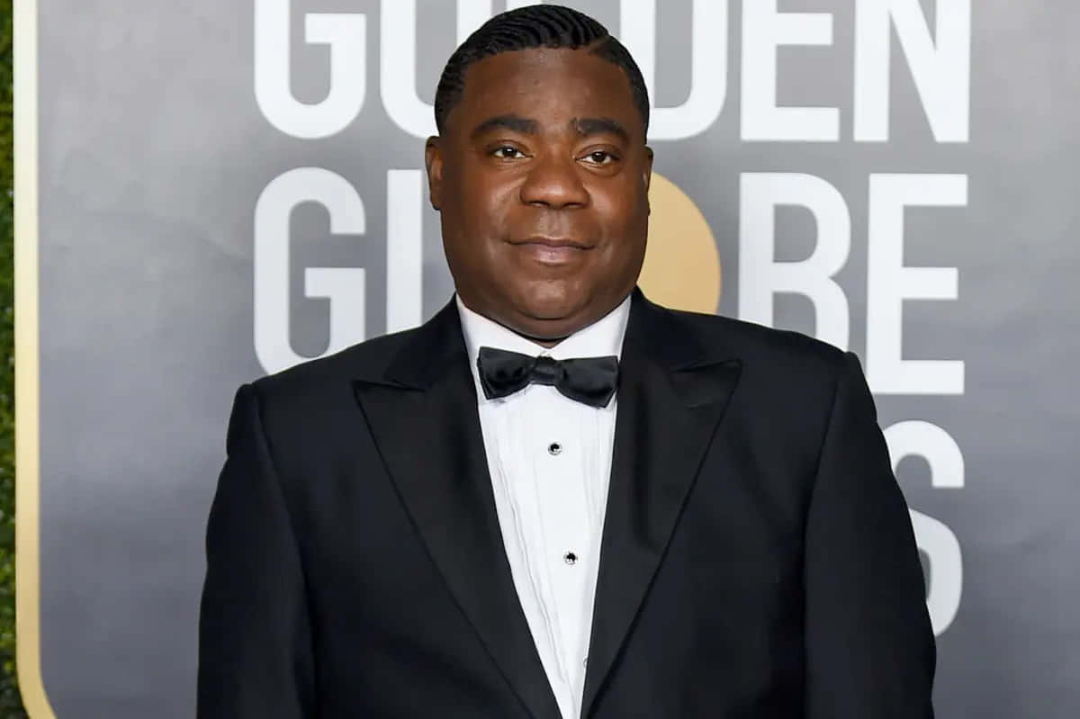 Tracy Morgan 桌布 壁紙 — 一名身穿黑色燕尾服配蝴蝶結的男子自信地站在金球獎紅毯活動上。