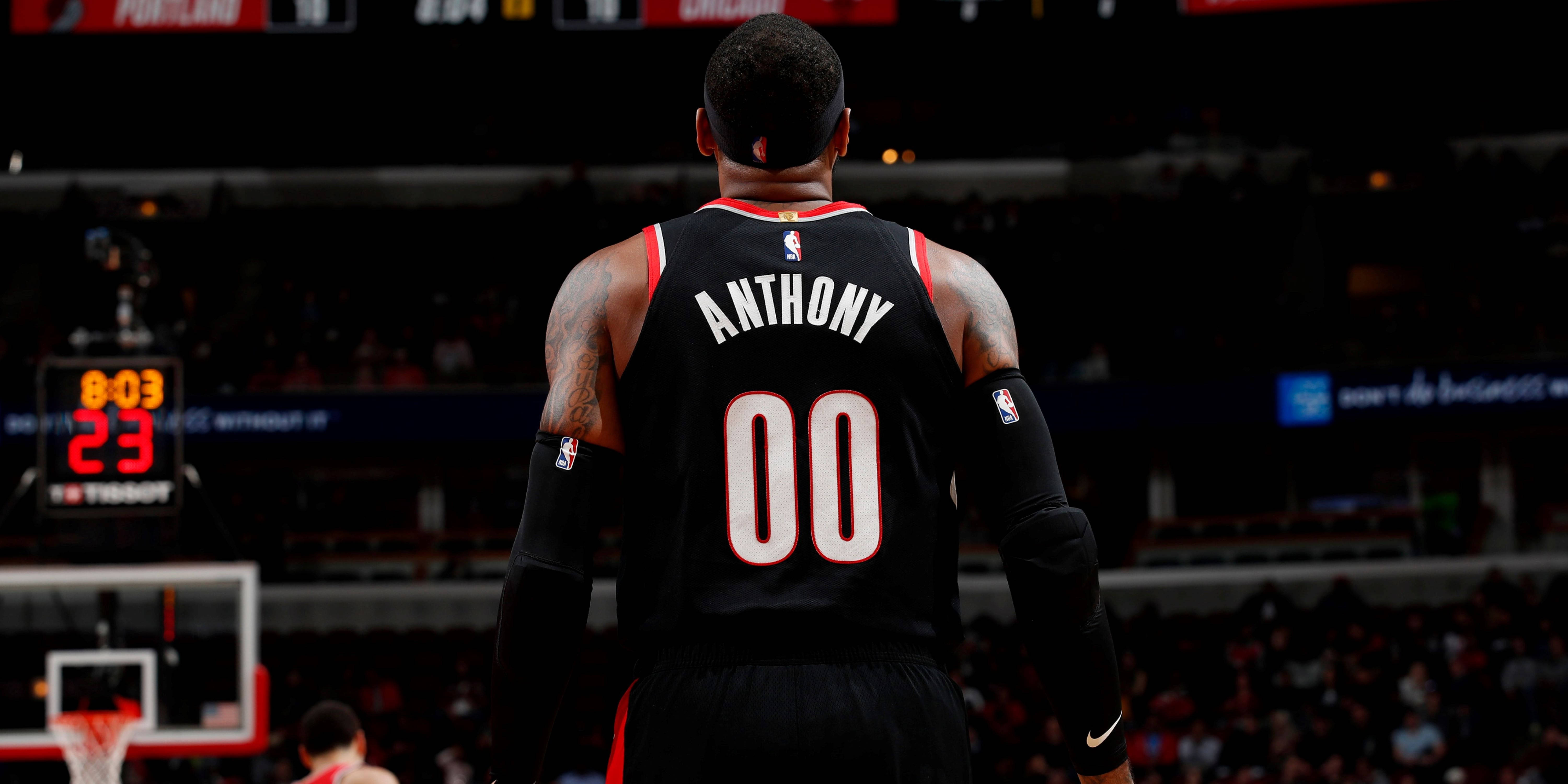 Carmelo 桌布 壁紙 — 一名身穿黑色球衣、印有Anthony和00號的籃球運動員站在球場上，面對顯示8:03和23的記分牌。