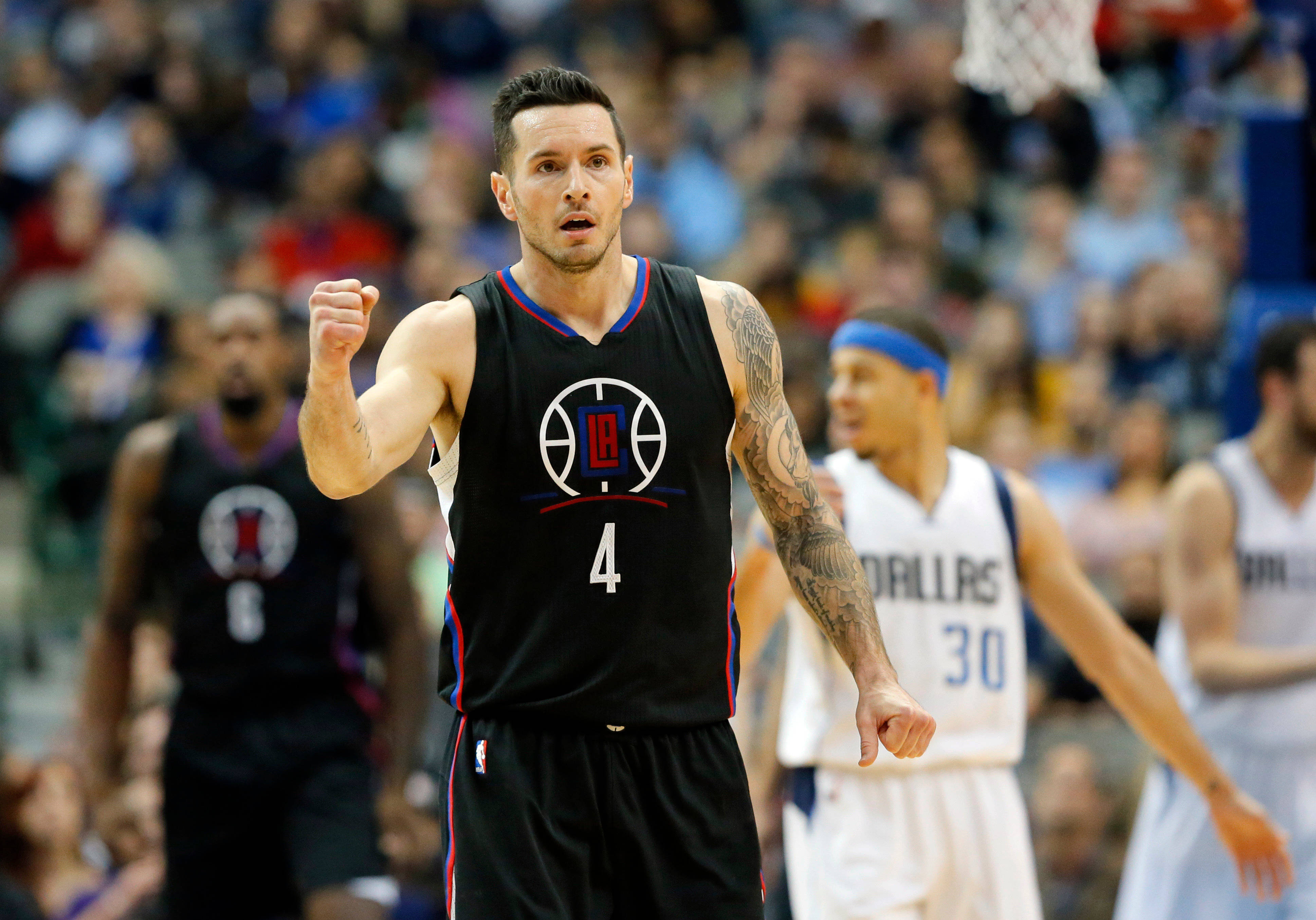 Jj Redick 桌布 壁紙 — 一名身穿黑色球衣、背號4號的籃球運動員在比賽中握緊拳頭，隊友和對手站在附近。