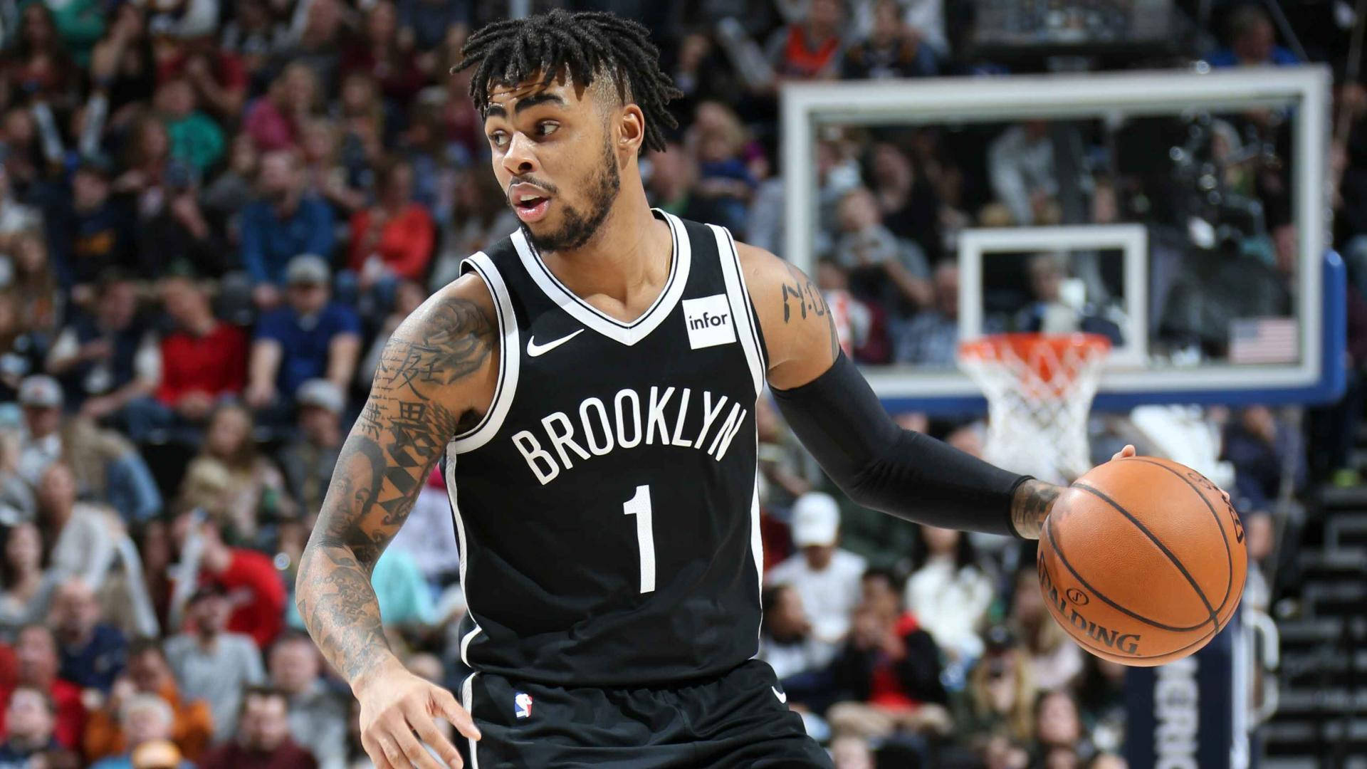 NBA 桌布 壁紙 — 一名身穿黑色球衣的布魯克林籃網籃球運動員在激烈的比賽中運球，背景是座無虛席的人群。