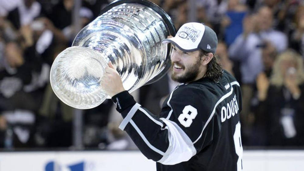 hockey 桌布 壁紙 — 一名身穿黑色球衣的曲棍球手在歡呼的人群面前高舉史丹利盃，露出勝利的笑容。
