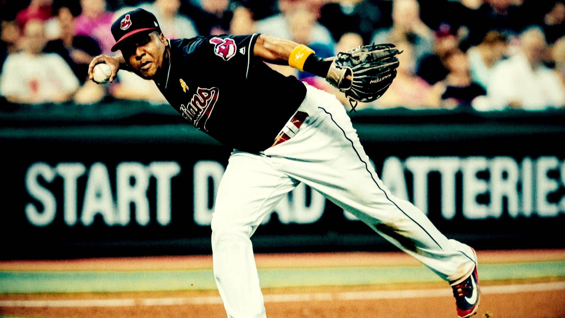 Jose Ramirez 桌布 壁紙 — 一名身穿黑色球衣的棒球選手在夜間比賽中，在球場燈光下專注地投球。