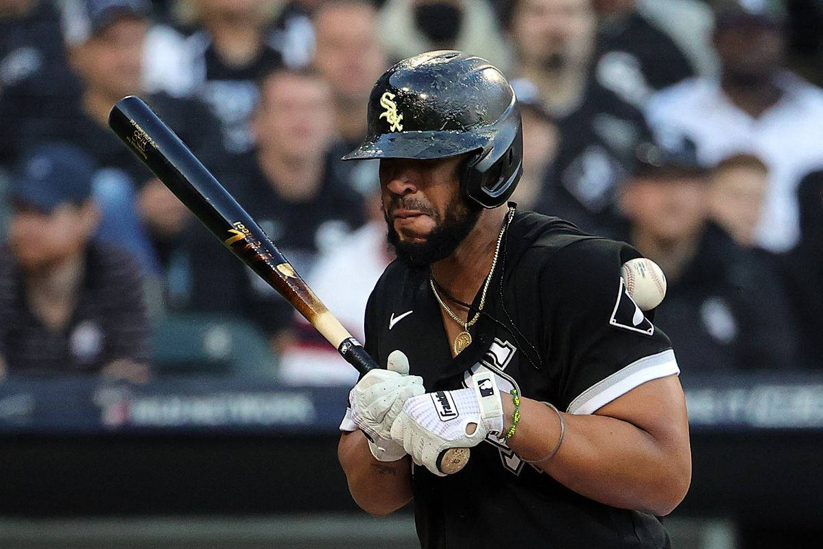 jose abreu 桌布 壁紙 — 一名身穿黑色球衣的棒球選手在夜間比賽中，在球場燈光下，專注地握著球棒揮擊中段。