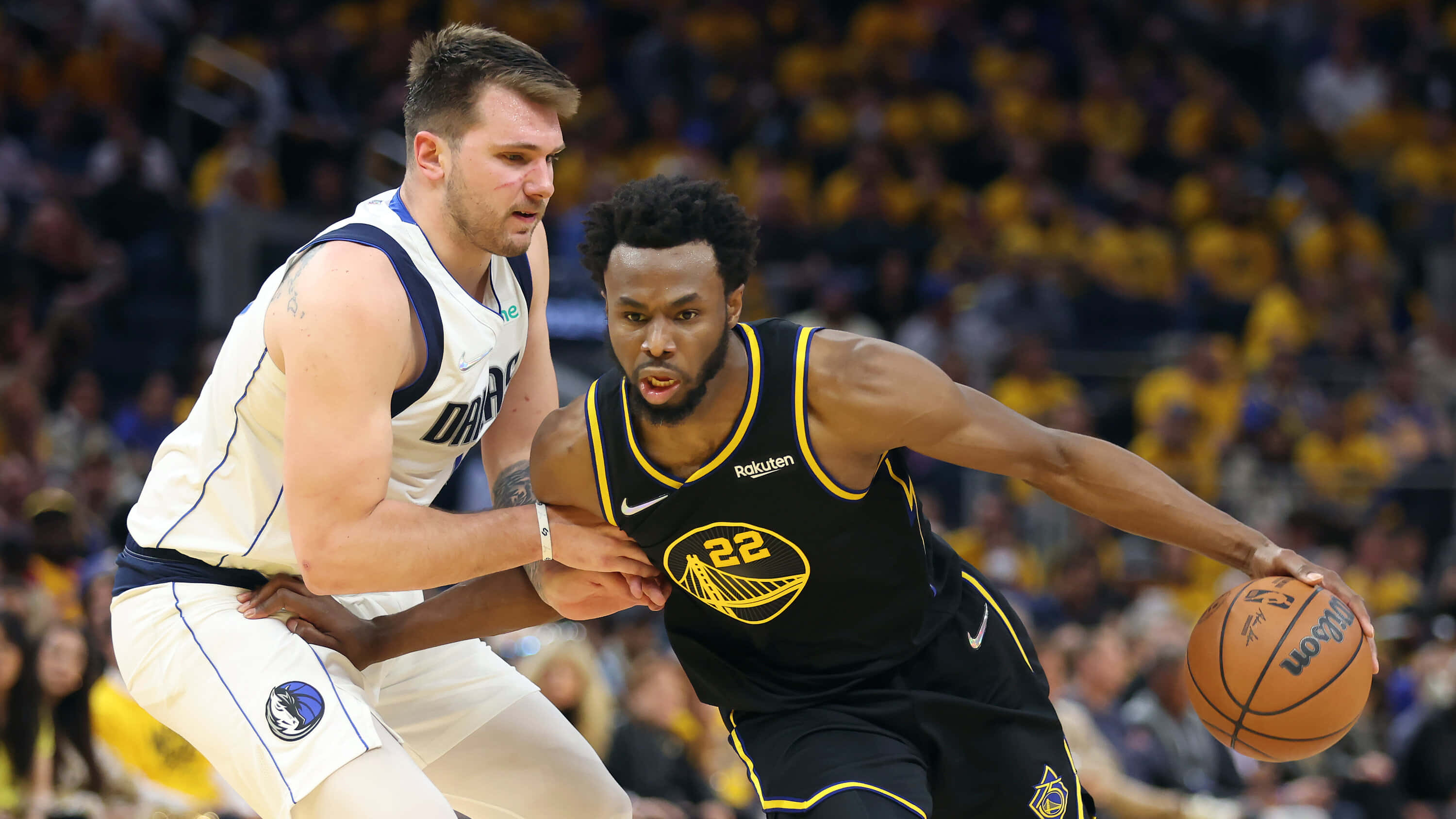Andrew Wiggins 桌布 壁紙 — 一名身穿黑色球衣的籃球運動員在比賽中運球，同時被一名身穿白色球衣的對手緊密防守。