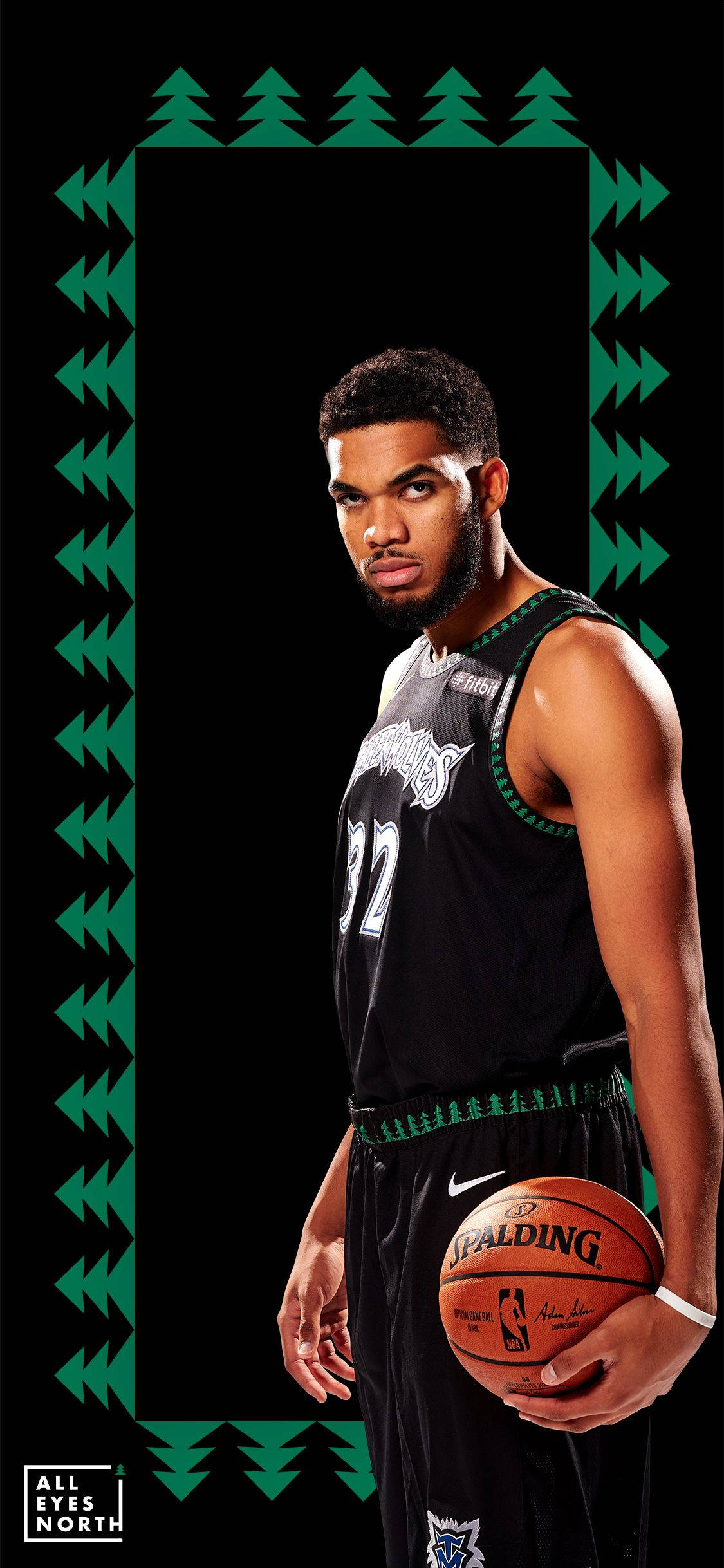 karl-anthony towns 桌布 壁紙 — 一名身穿黑色球衣的籃球運動員在黑色背景前拿著Spalding籃球，背景由綠色松樹圖案框住。