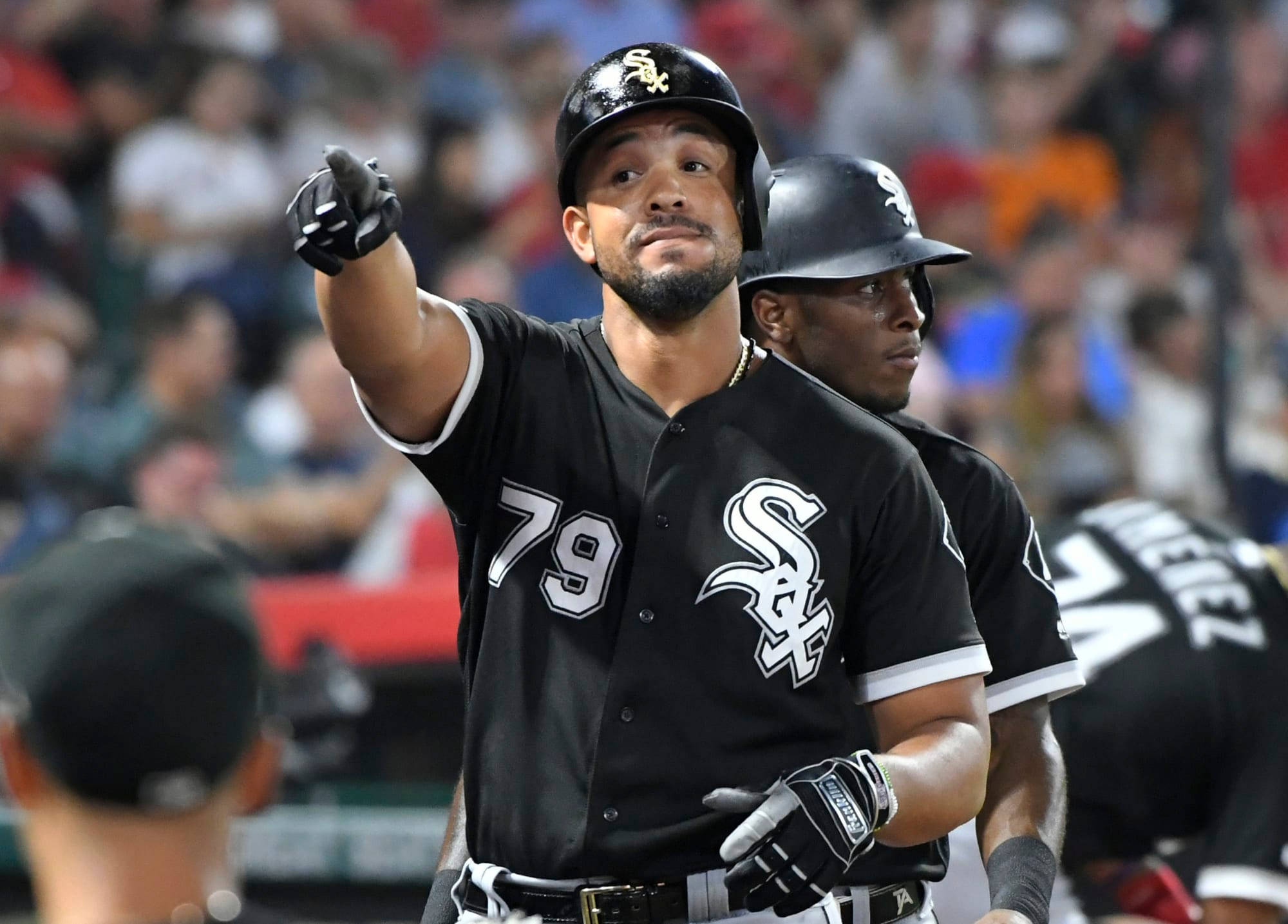 jose abreu 桌布 壁紙 — 一名身穿黑色球衣的芝加哥白襪棒球選手在夜間比賽中，於球場燈光下專注地向上指。