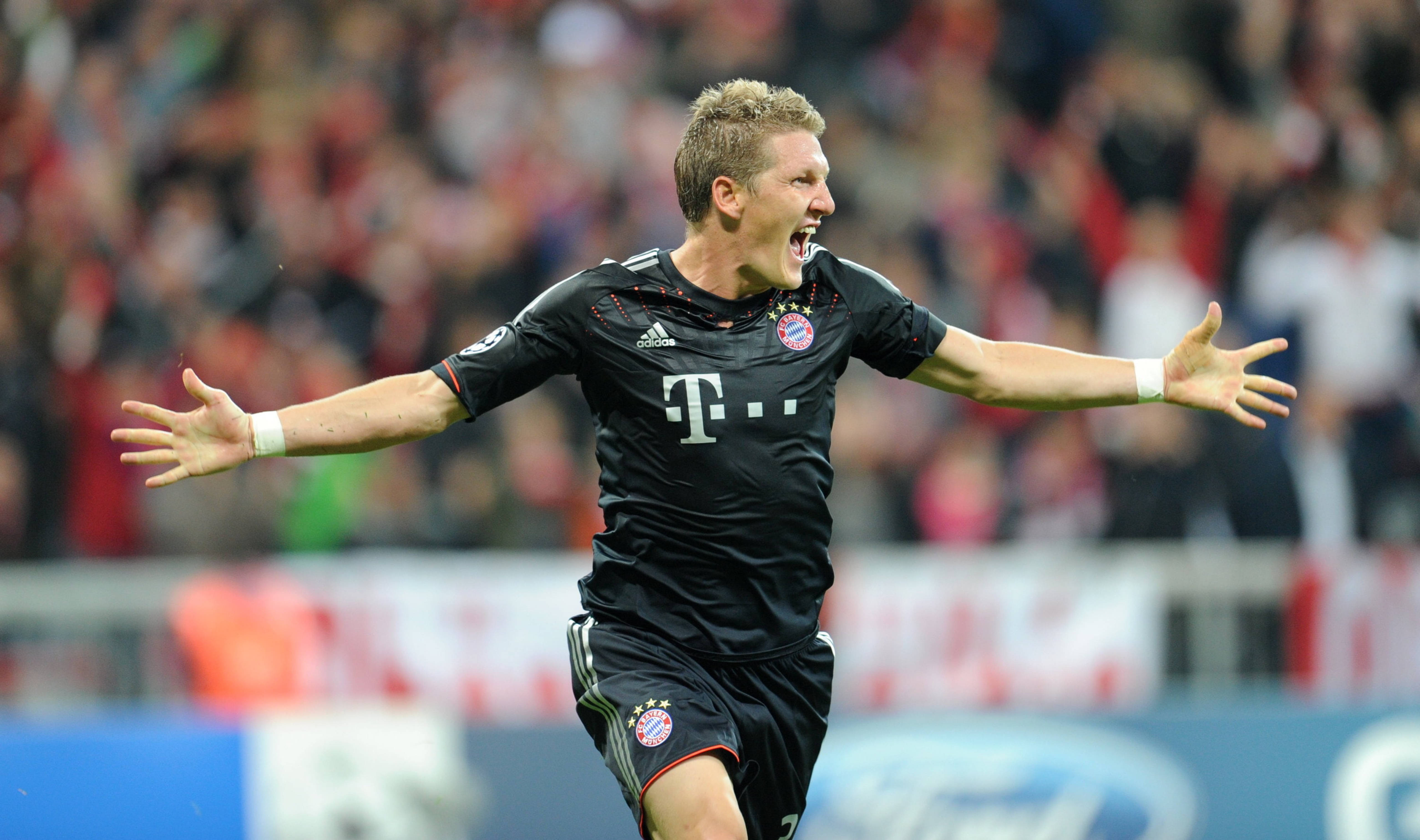 Bayern 桌布 壁紙 — 一名身穿黑色球衣的足球運動員在球場上張開雙臂勝利地慶祝。