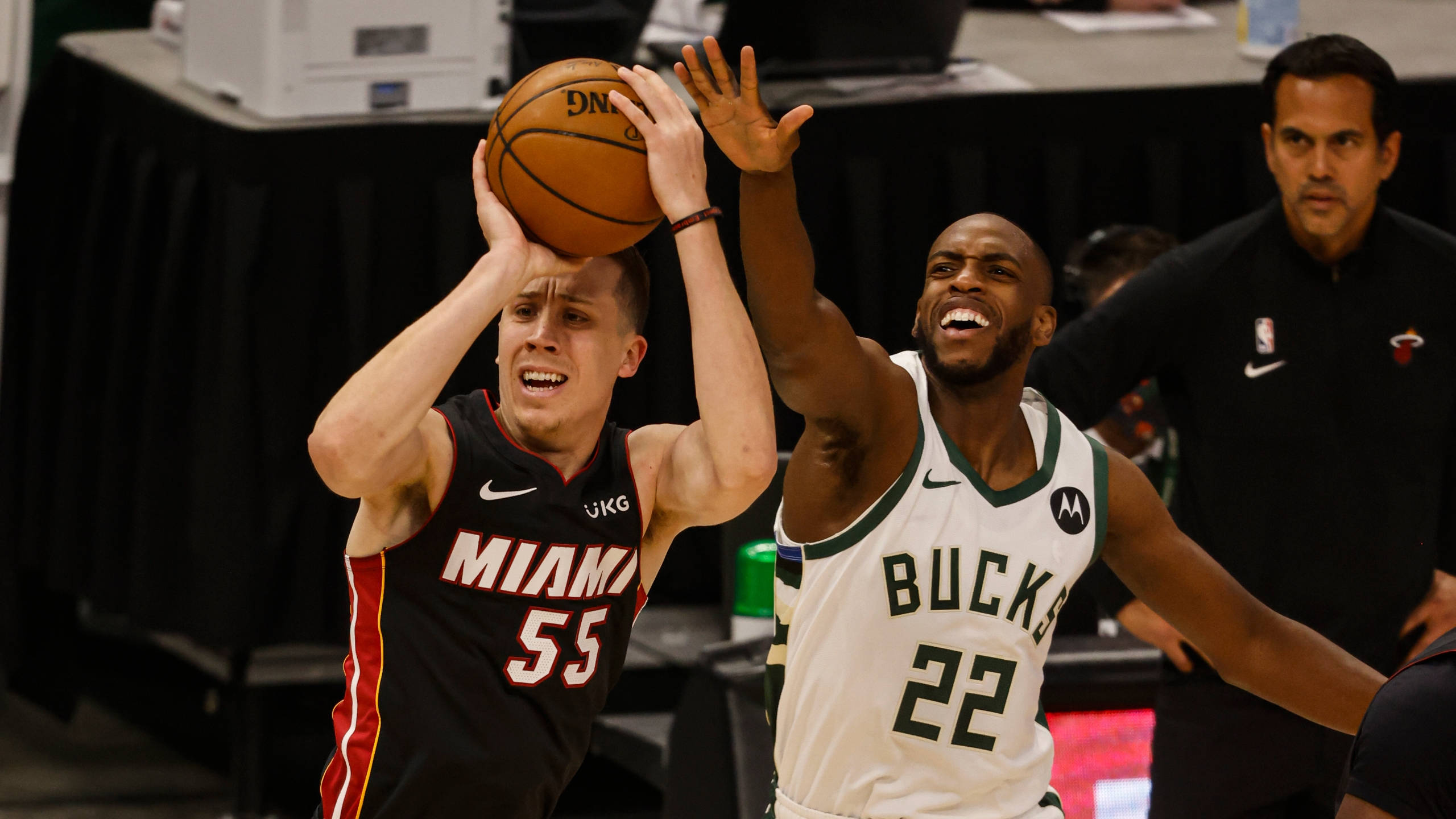 Khris Middleton 桌布 壁紙 — 一名身穿黑色球衣的邁阿密熱火球員正在投籃，而一名身穿白色球衣的密爾瓦基公鹿防守球員跳起嘗試封阻。