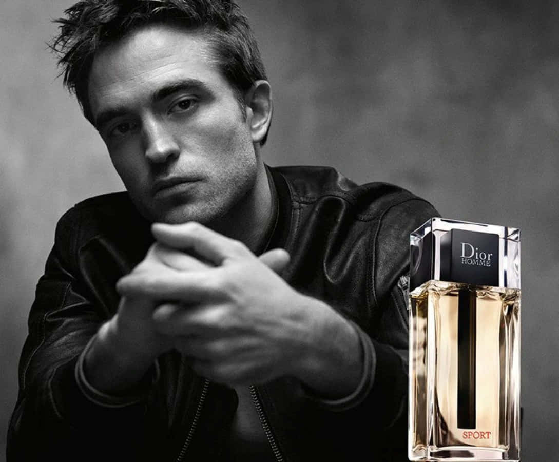 Dior 動態 桌布 壁紙 — 一名身穿黑色皮夾克的男子在單色工作室拍攝中，專注地凝視著 Dior Homme Sport 香水瓶旁邊。