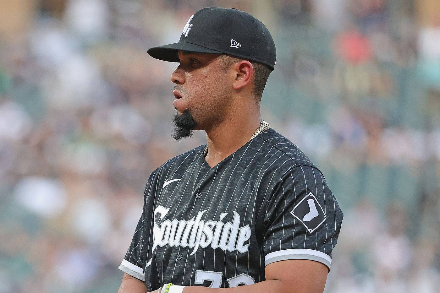 jose abreu 桌布 壁紙 — 一名身穿黑色細條紋Southside球衣的棒球運動員專注地站在球場上，身後是模糊的體育場人群。