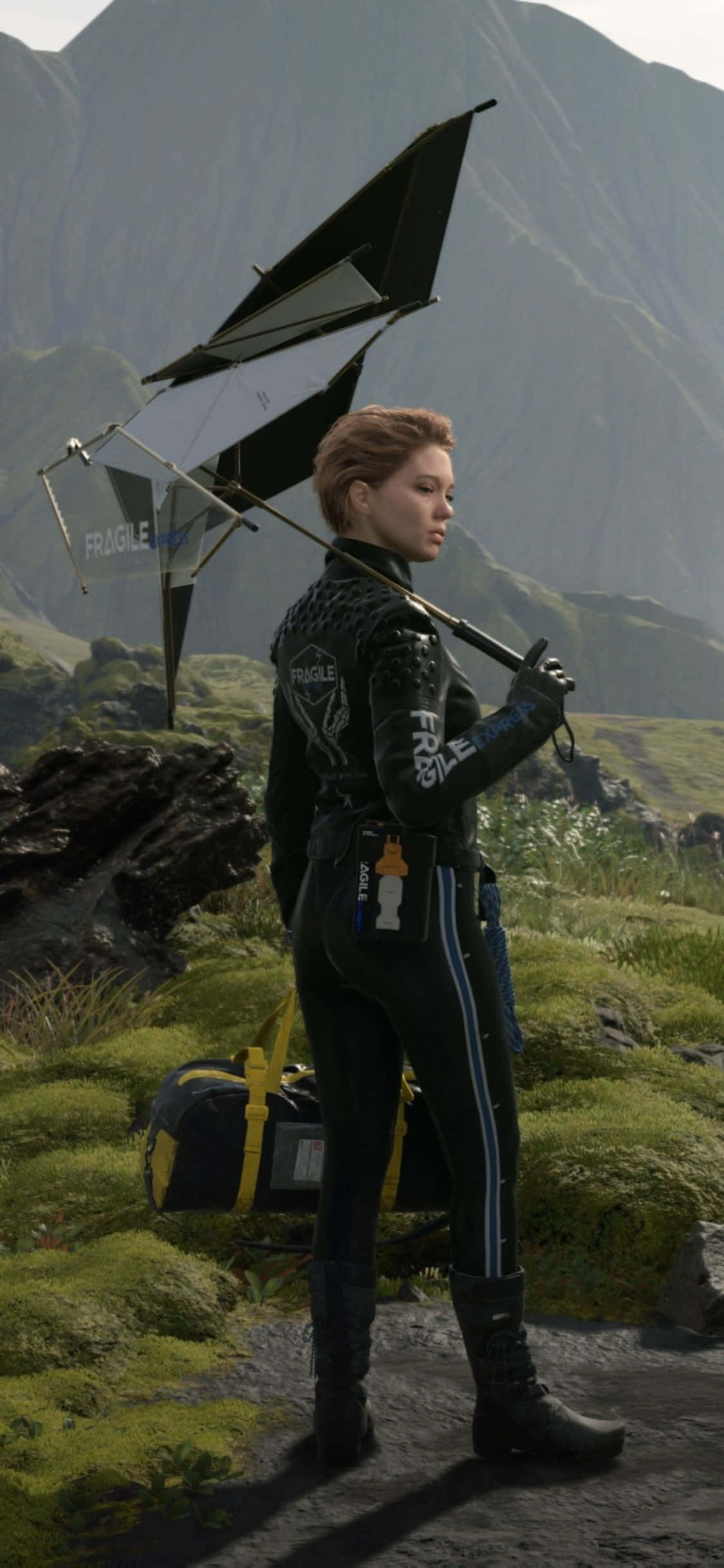 iPhone Xs Death Stranding 桌布 壁紙 — 一名身穿黑色裝備的女子，帶著一把脆弱的雨傘和行李袋，穿過長滿苔蘚的山間小徑。