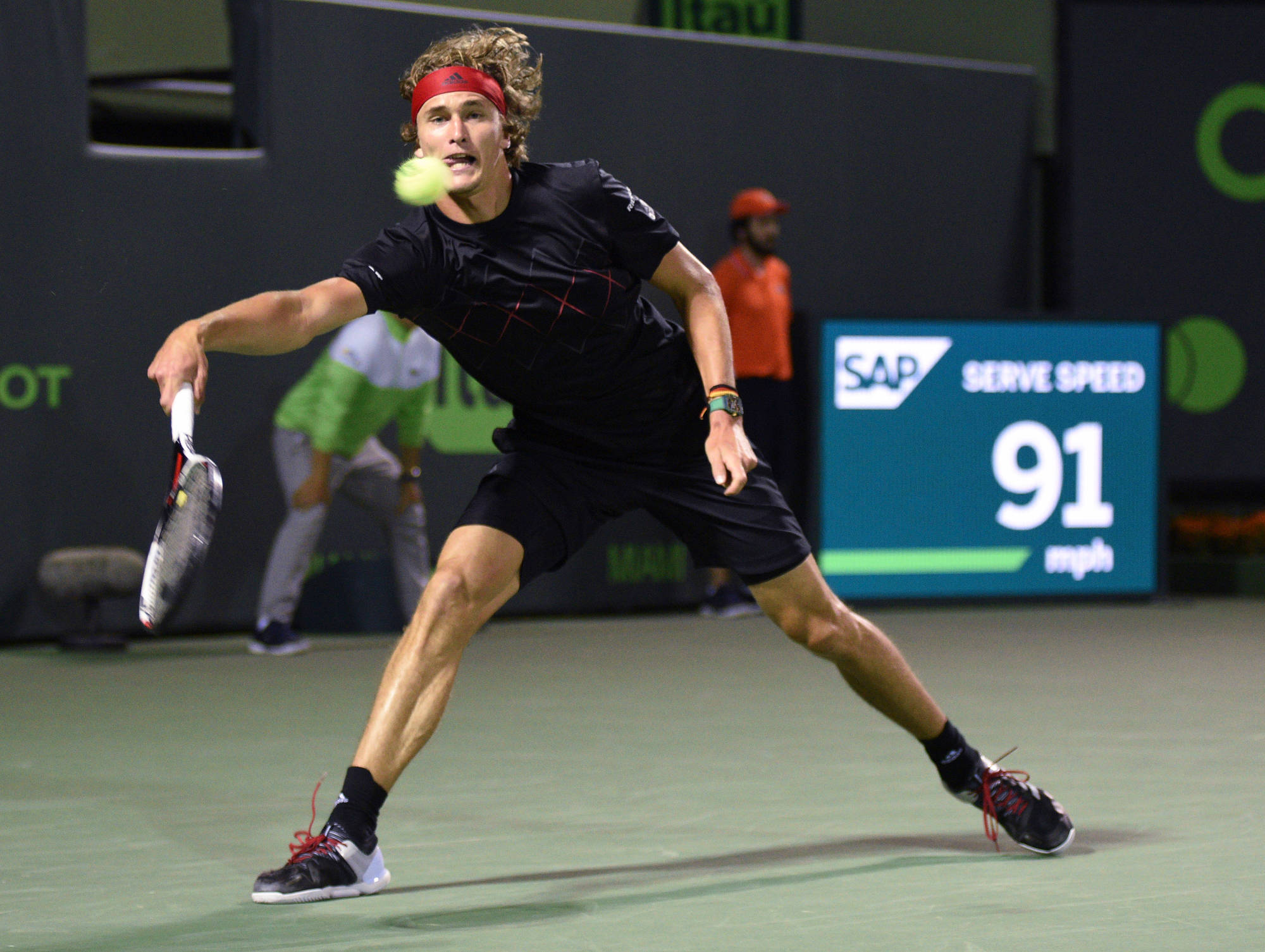 alexander zverev 桌布 壁紙 — 一名身穿黑色裝備的男性網球選手在綠色球場上執行強力發球，數位計分板顯示時速91英里。
