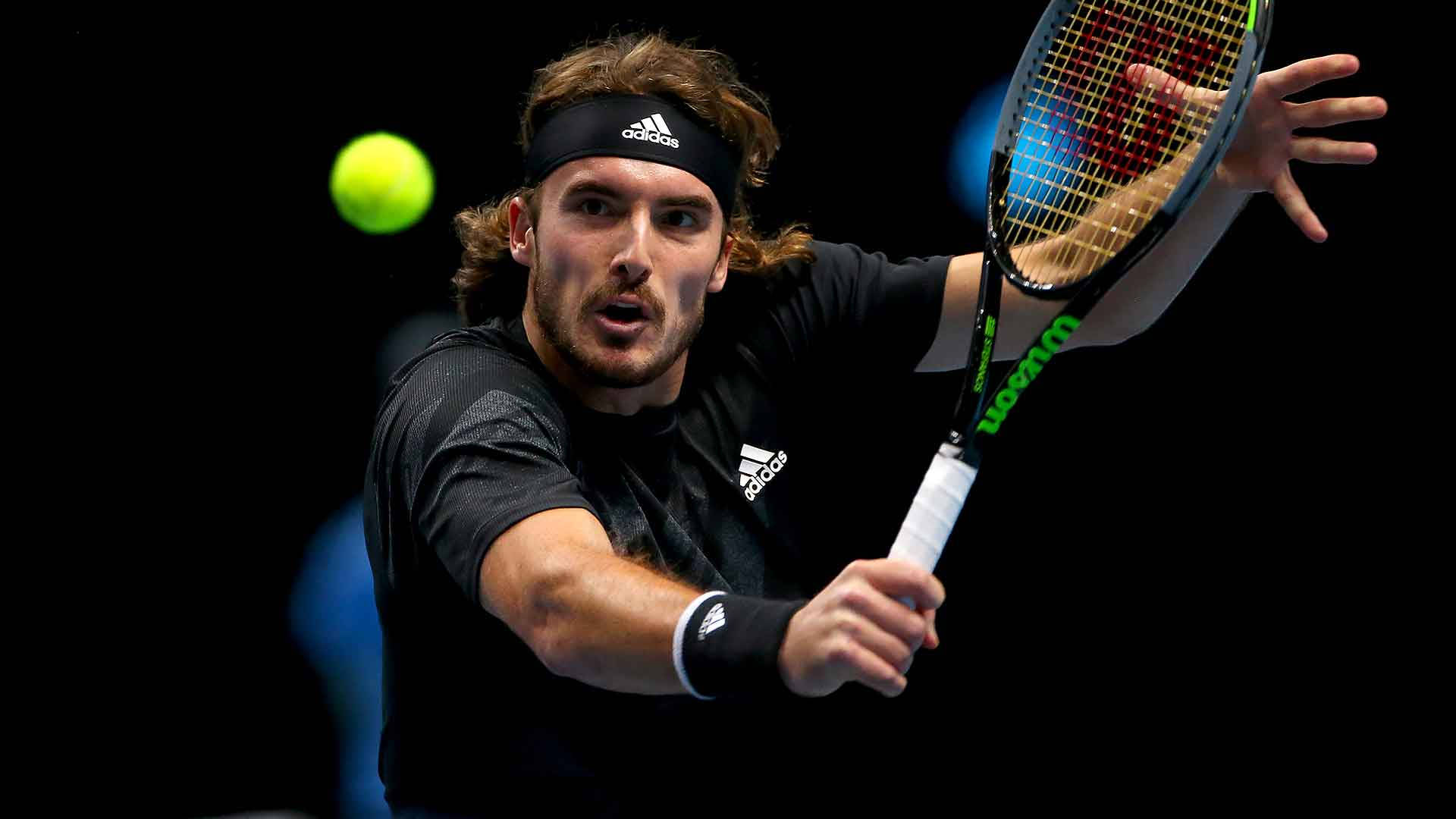 Athletic 桌布 壁紙 — 一名身穿黑色裝備的男網球選手在黑暗背景下揮拍擊打發光的綠色球。